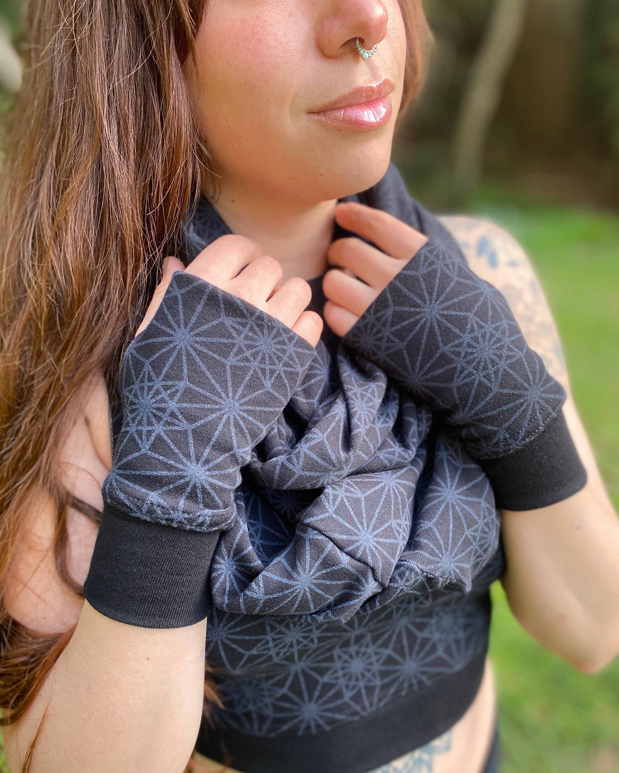 Organic cotton hand warmers and matching scarf in black fabric and geometric print, right side view on female model.