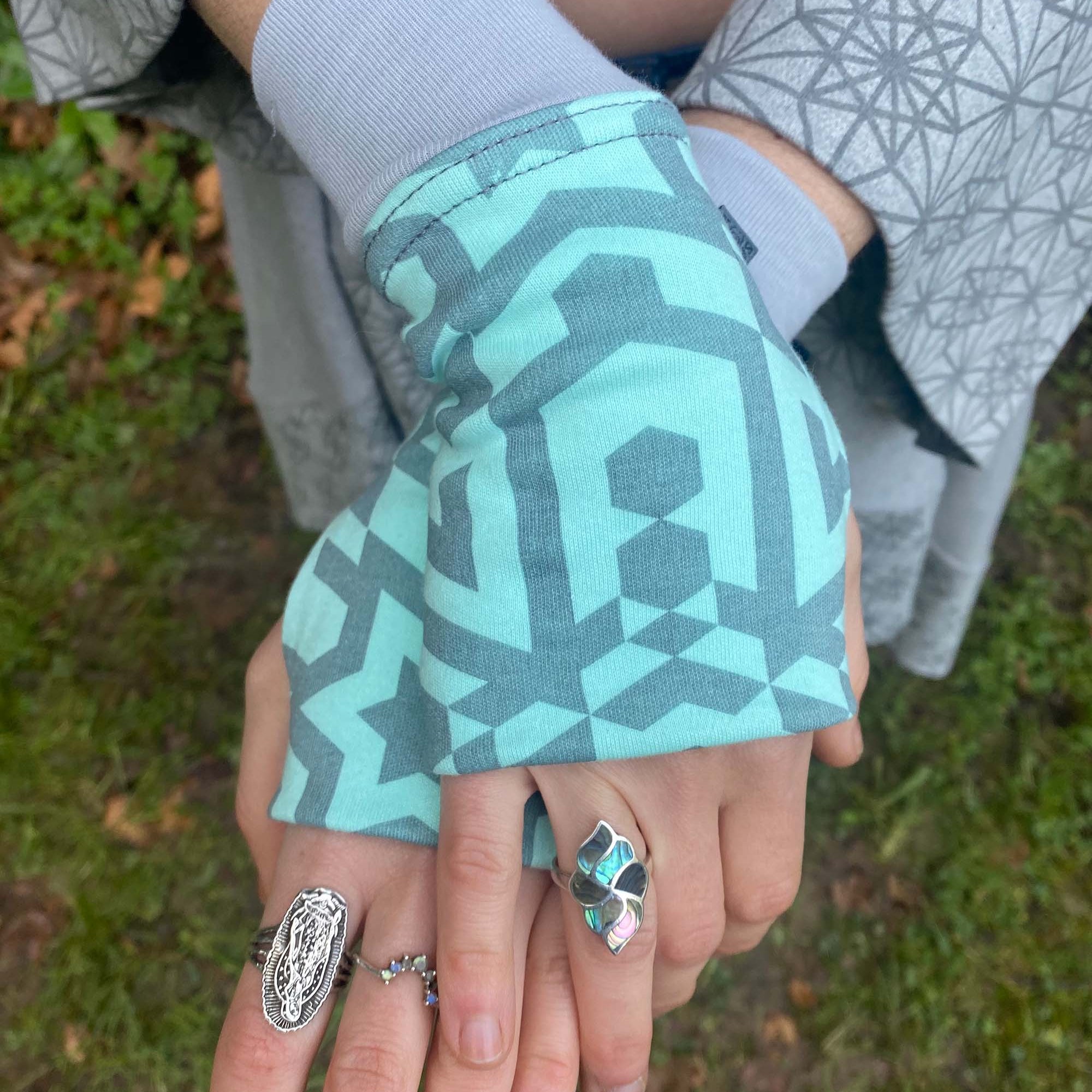 Organic cotton hand warmers mint colored fabric with geometric print, top detail view.