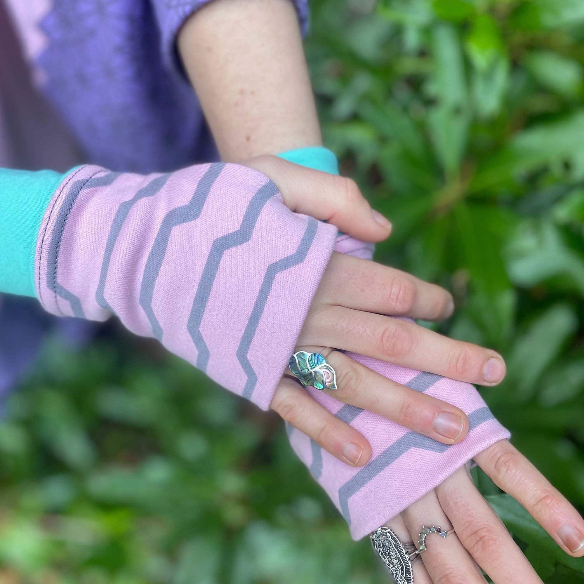 Organic cotton fingerless gloves in pink fabric with geometric print, right hand view.