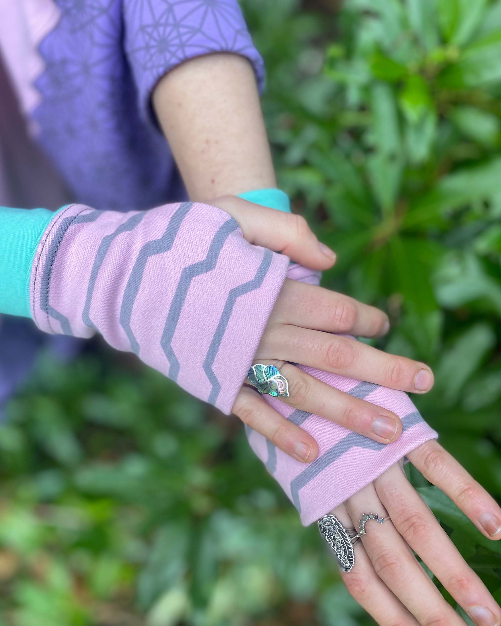 Organic cotton fingerless gloves in pink fabric with geometric print, right hand view.