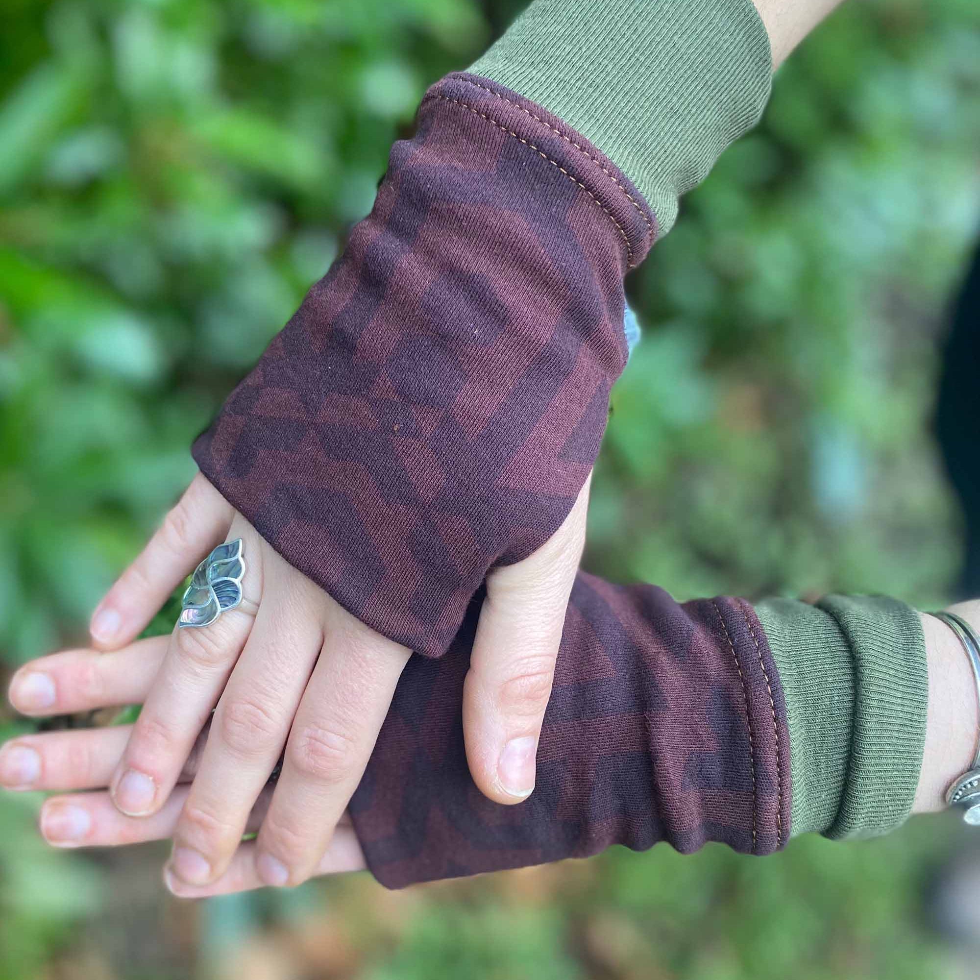Organic cotton hand warmers reddish brown colored fabric with geometric print and green accents, top detail view.