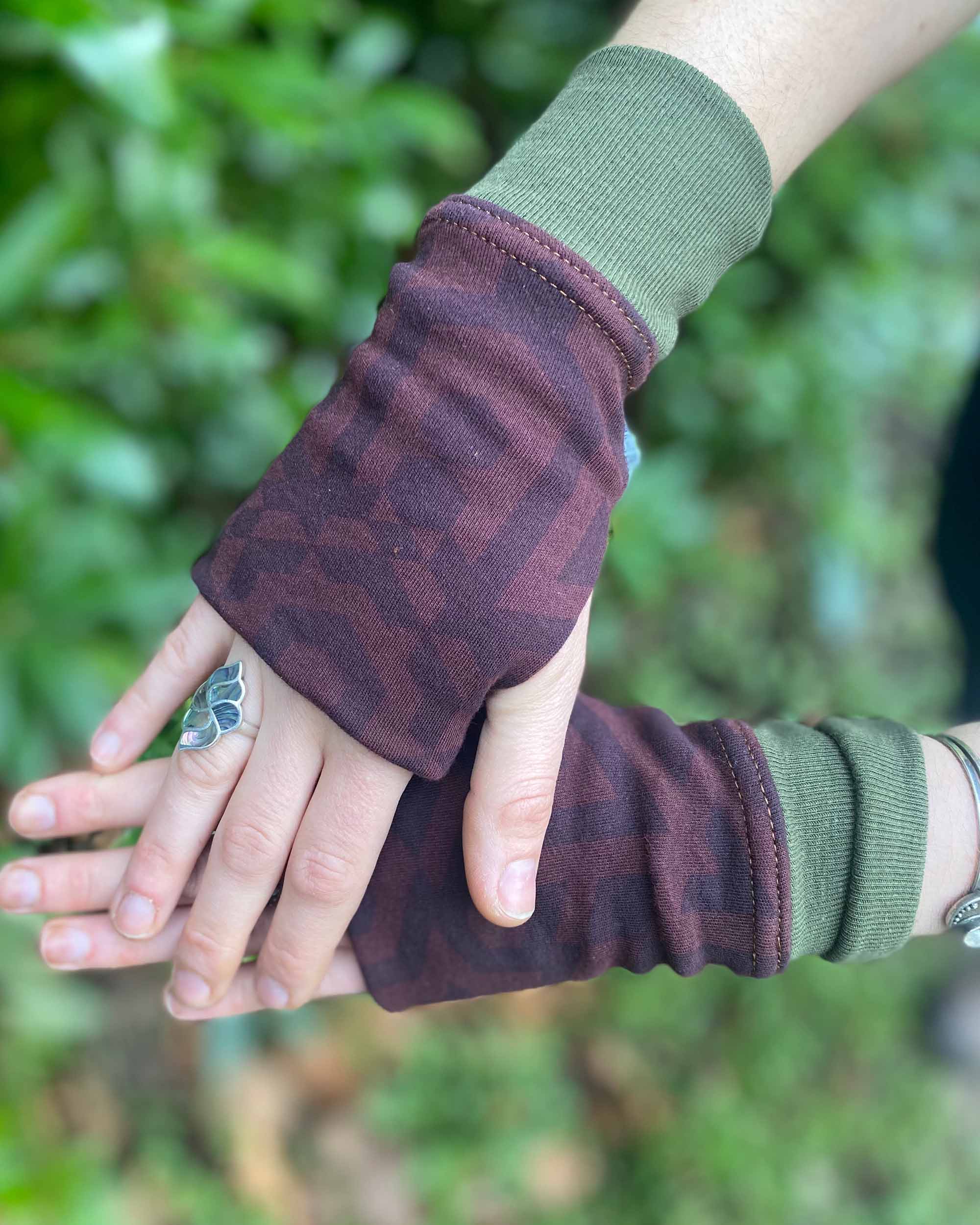 Organic cotton hand warmers reddish brown colored fabric with geometric print and green accents, top detail view.