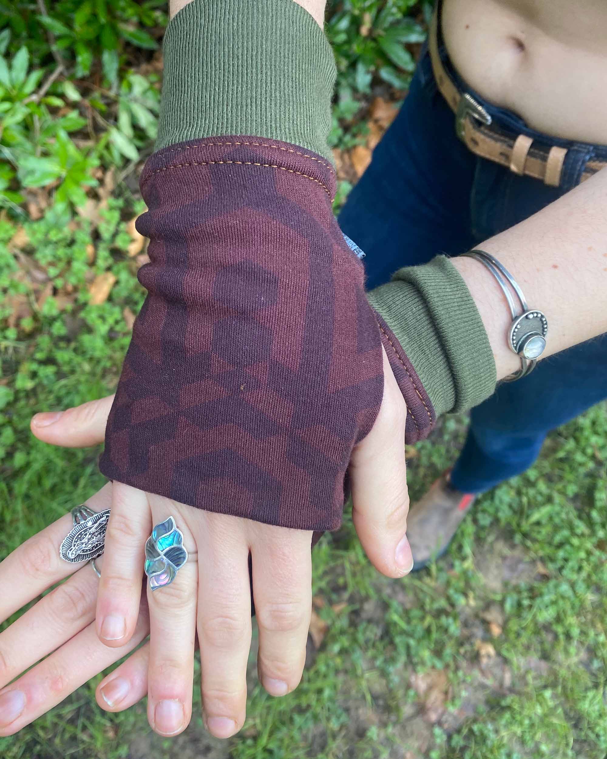 Organic cotton fingerless gloves in reddish brown colored fabric with geometric print, left hand view.