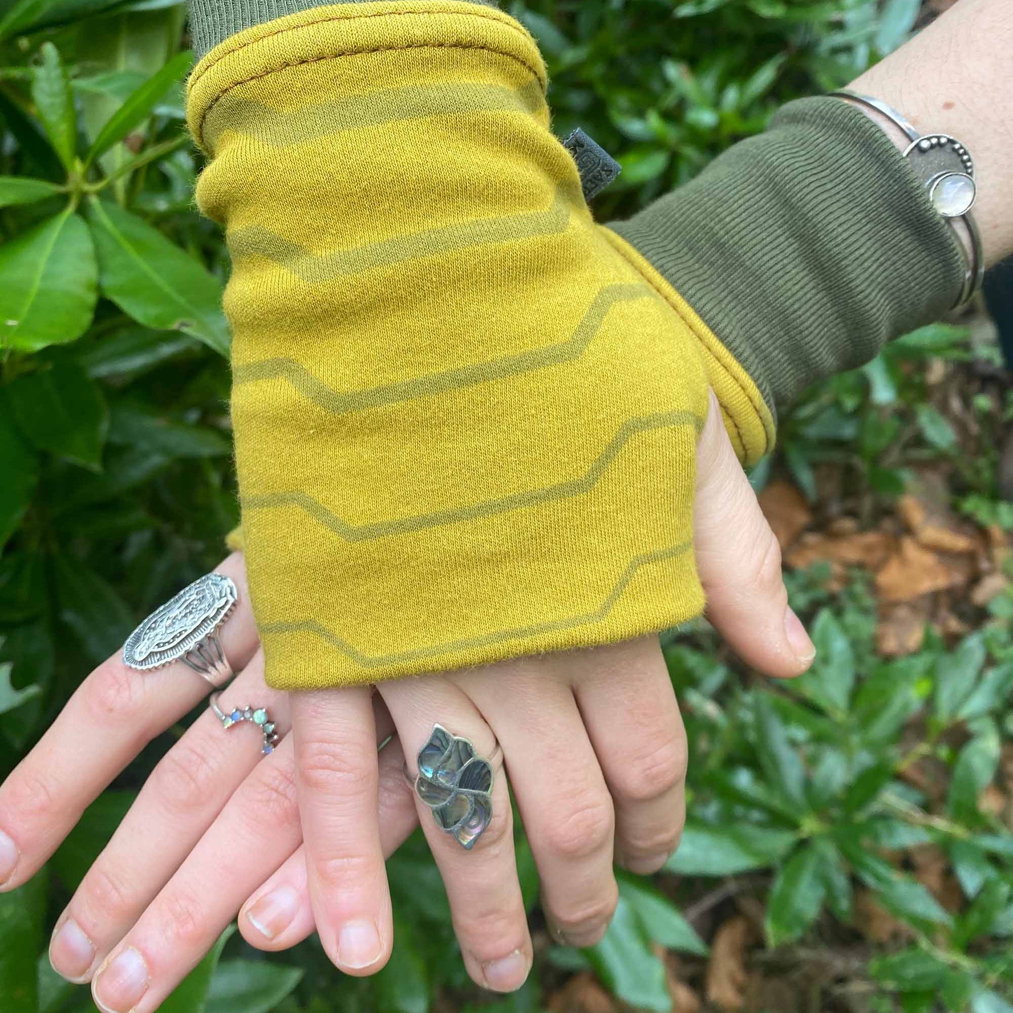Organic cotton fingerless gloves in yellow fabric with geometric print, top right hand view.