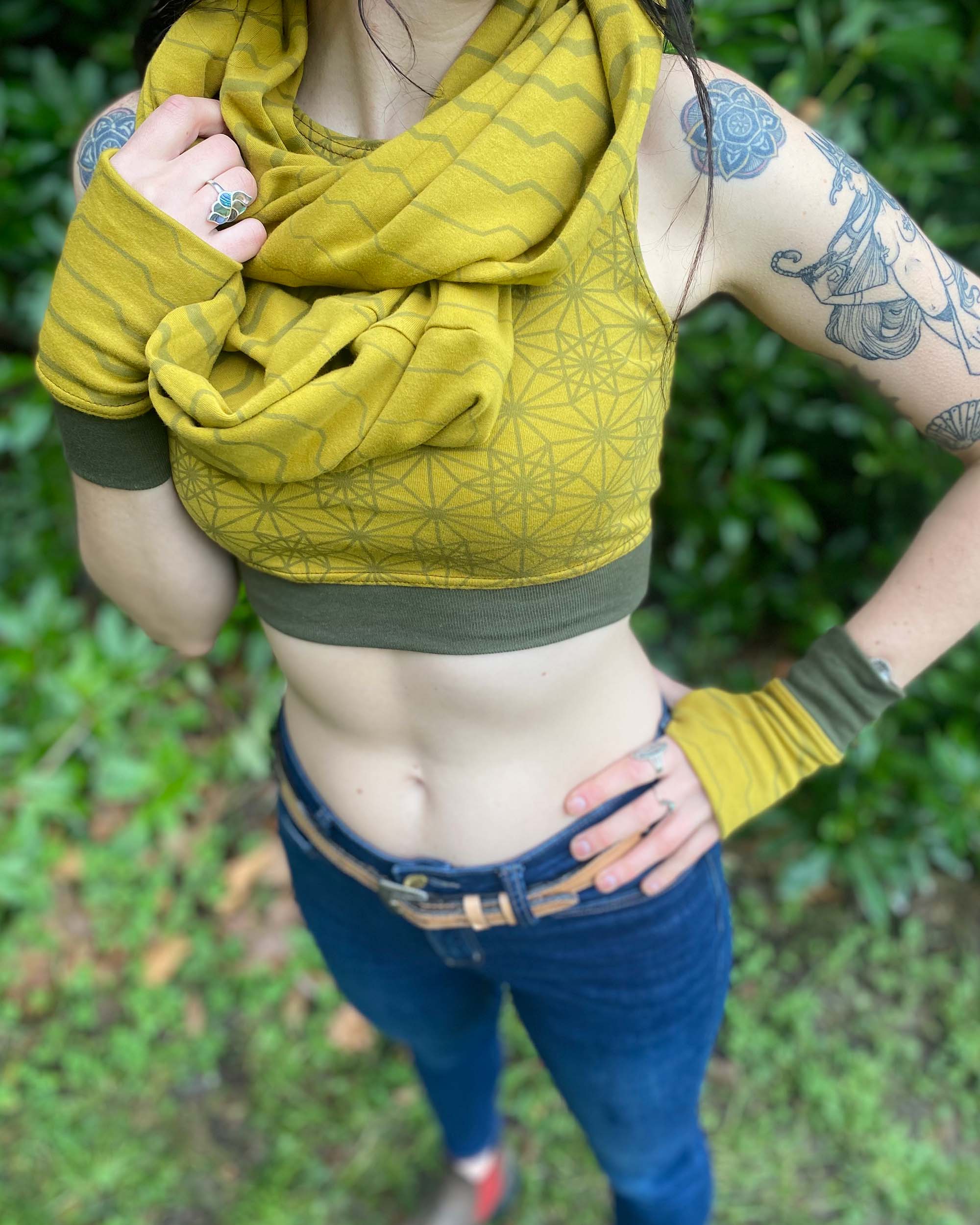 Organic cotton hand warmers, crop top and scarf in yellow fabric with geometric print, front view of female model.