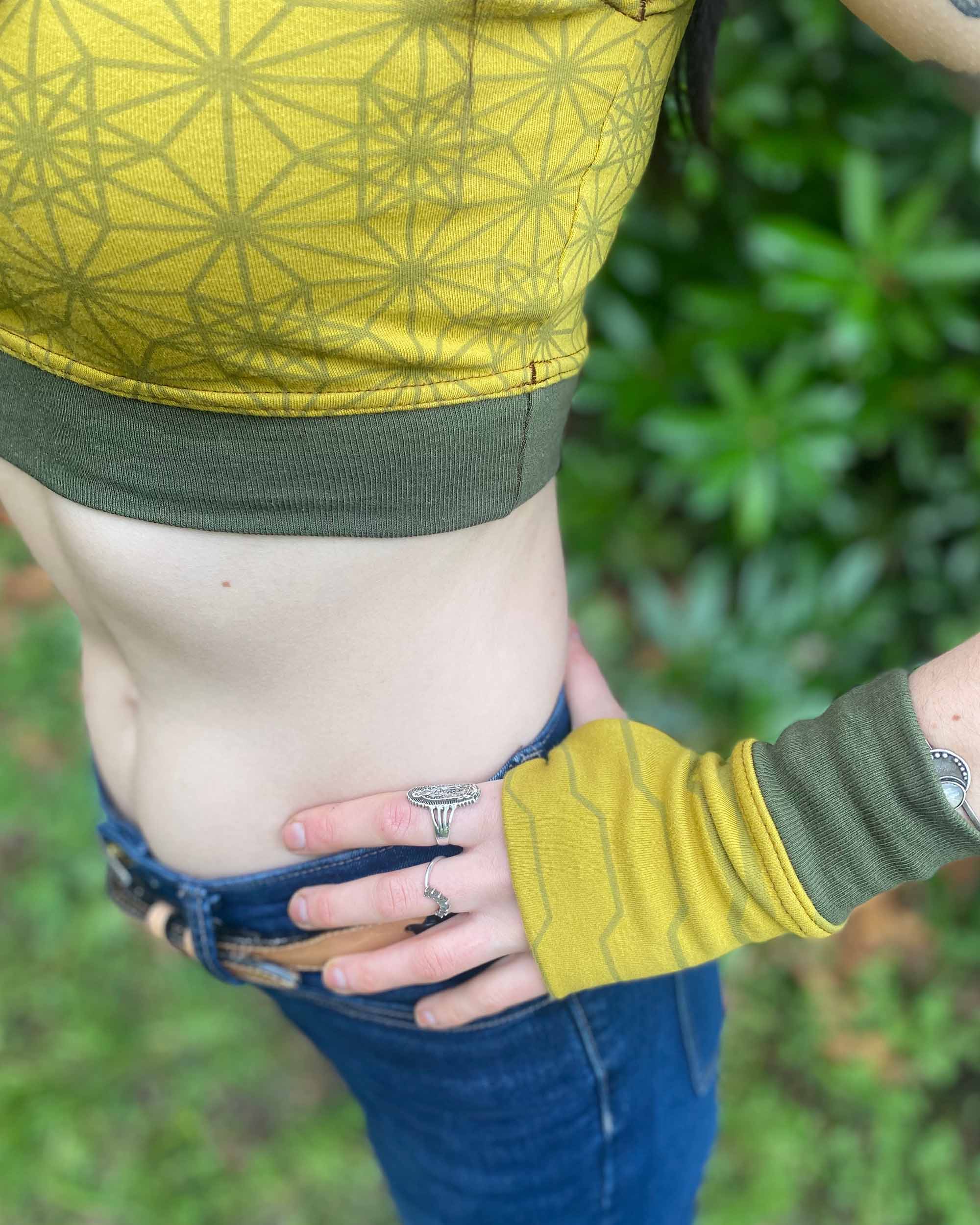 Organic cotton fingerless gloves, yellow fabric with geometric print, detail view.