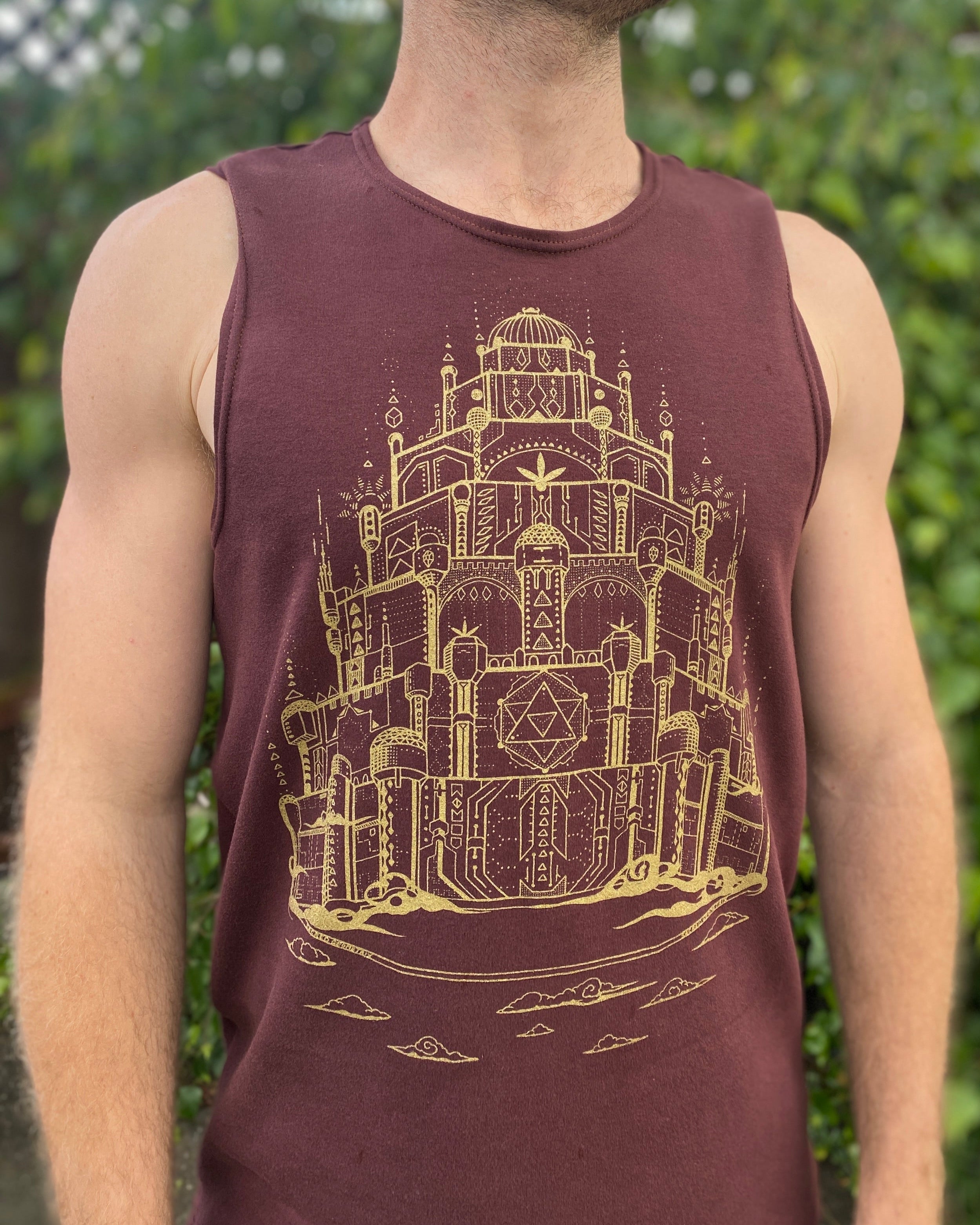 Man wearing a organic cotton brown tank top with a gold screen print design.