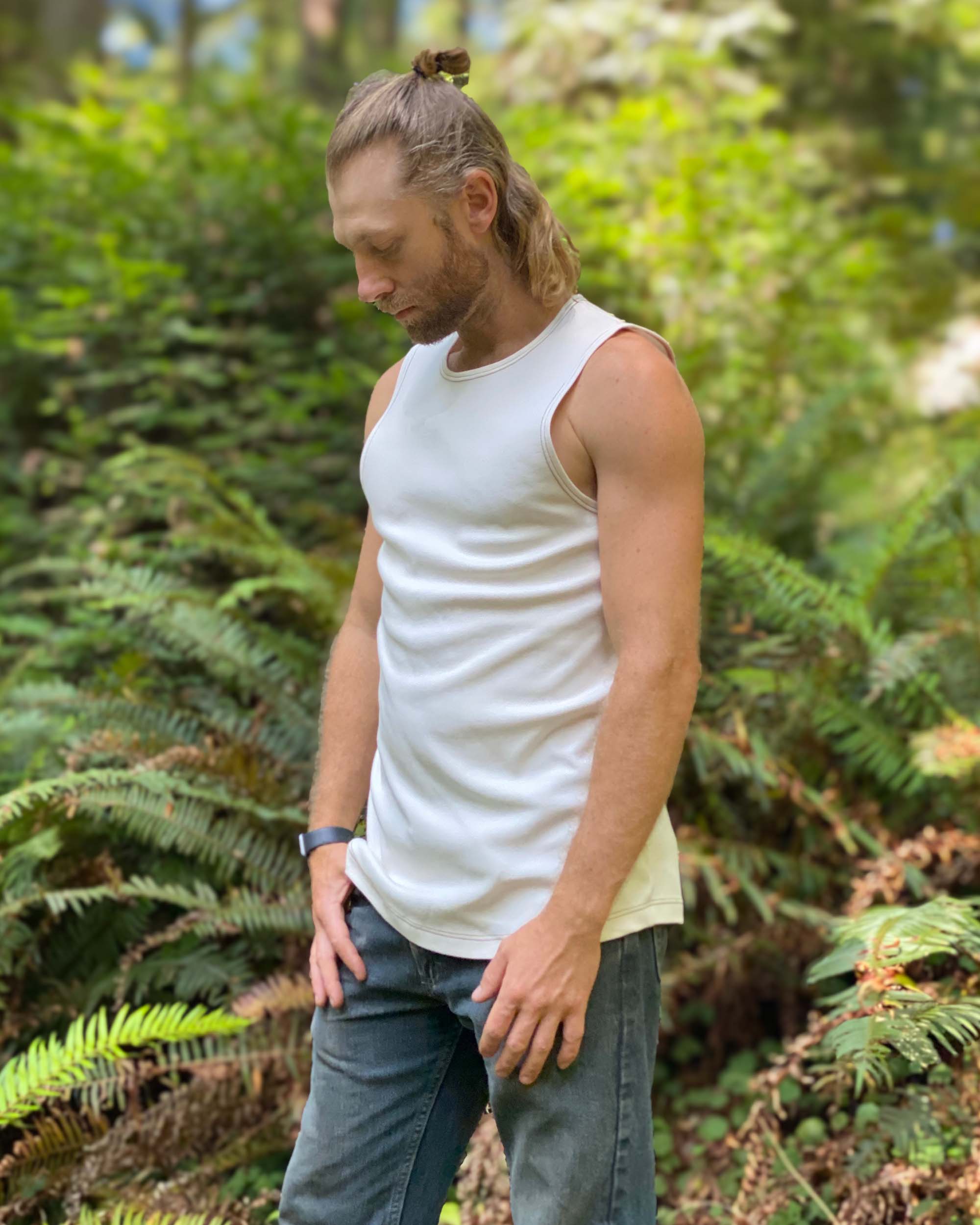 Organic cotton mens tank top, un-dyed fabric, left side view, in nature.