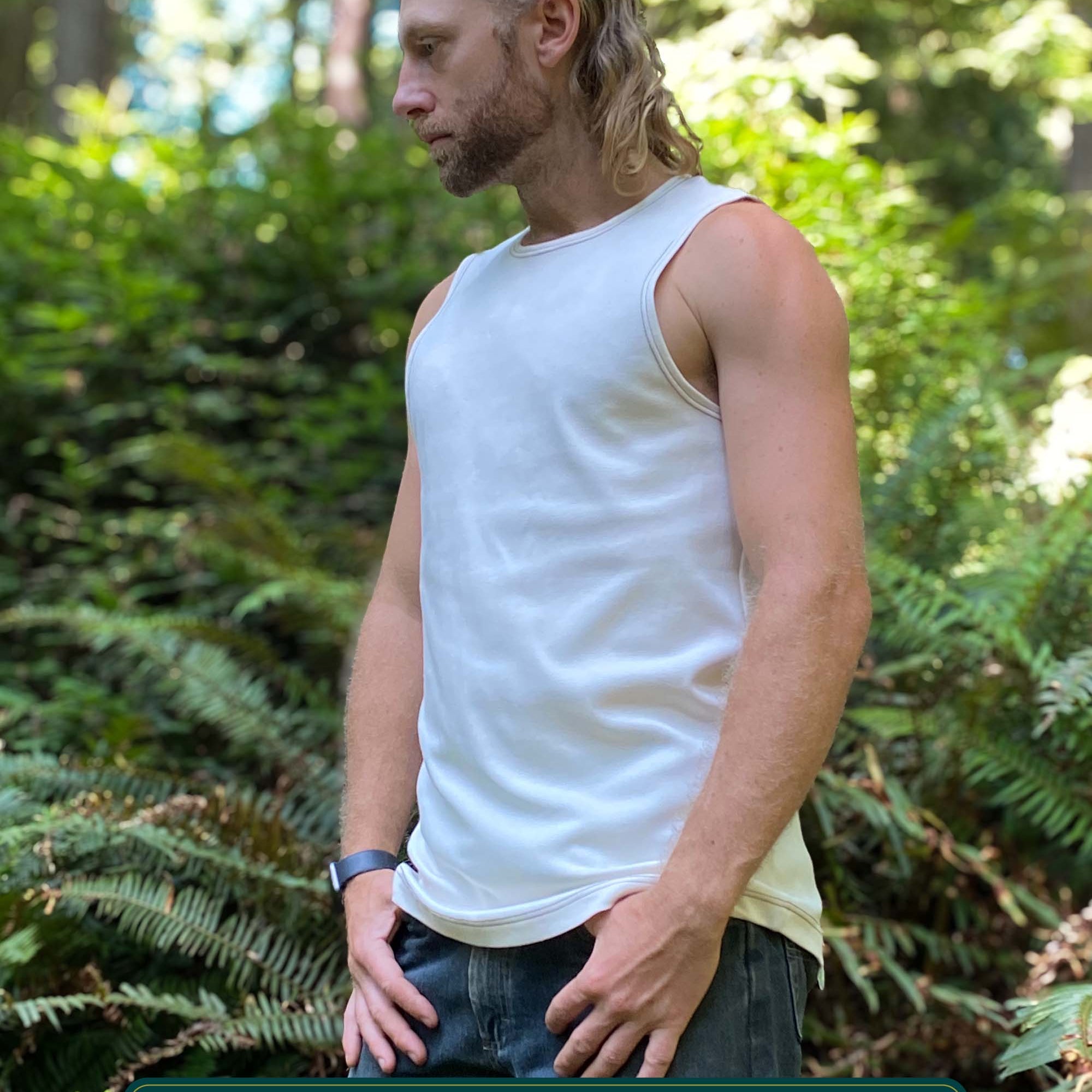 Organic cotton mens tank top, un-dyed fabric, left side view, on model in nature.
