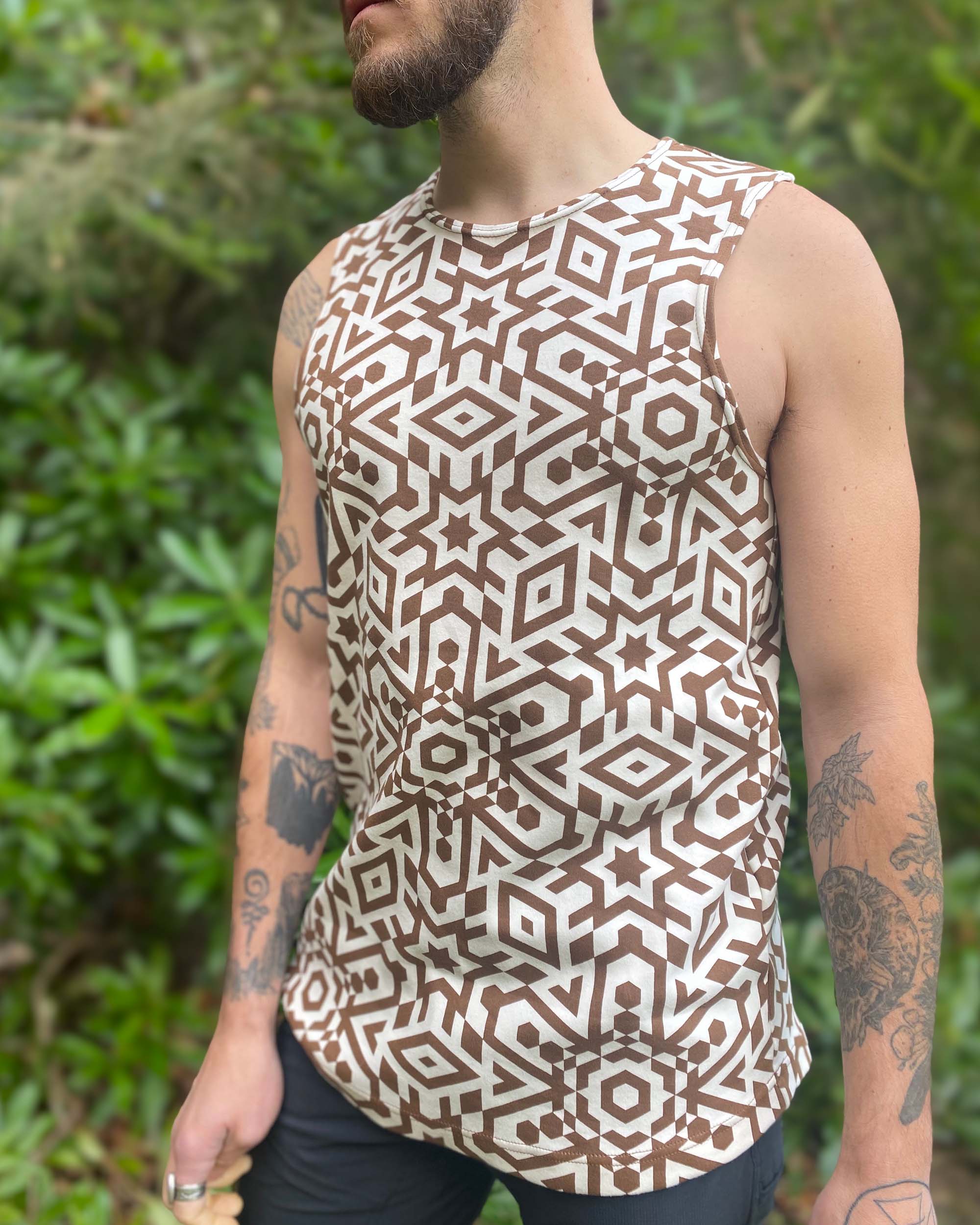 Organic cotton mens tank top, un-dyed fabric with brown geometric print, detail view on model.
