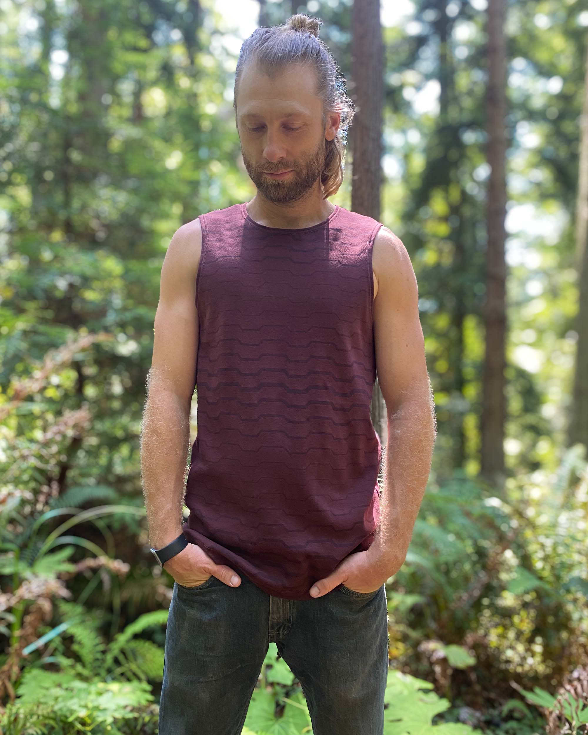Organic cotton mens tank top, brown fabric with geometric print, front view on model.
