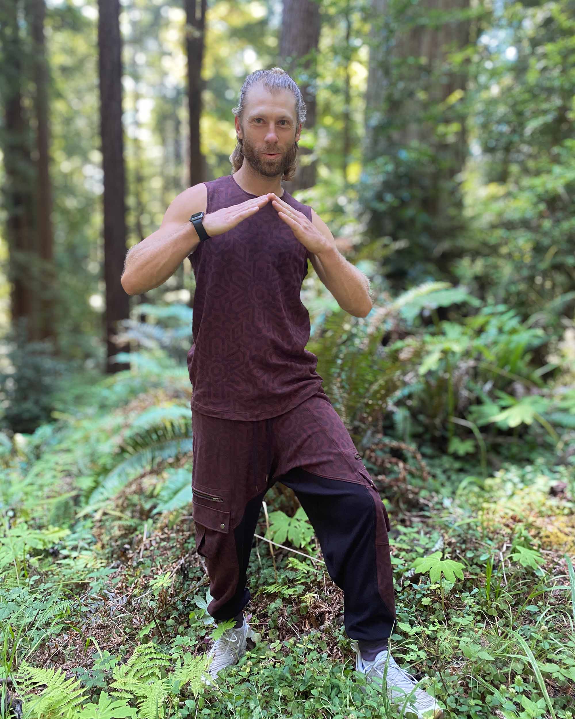 Organic cotton mens tank top, brown fabric with geometric print, front view on model outdoors.