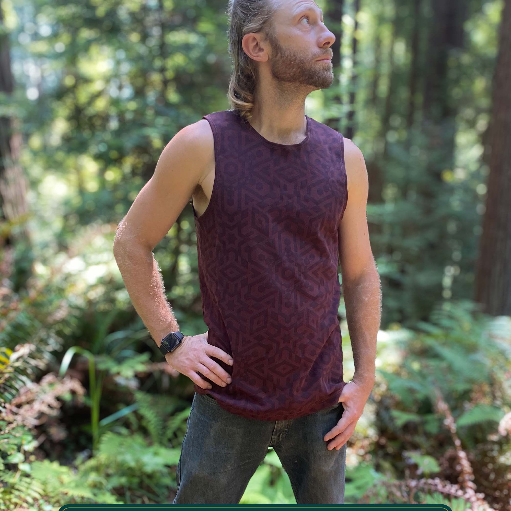 Organic cotton mens tank top, brown fabric with geometric print, left side view with model in natural light.