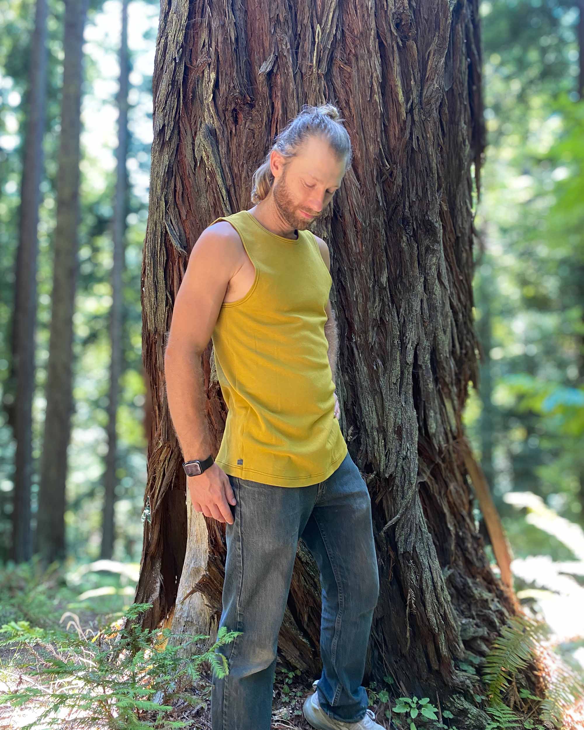 Organic cotton mens tank top, yellow fabric, left side view on model.