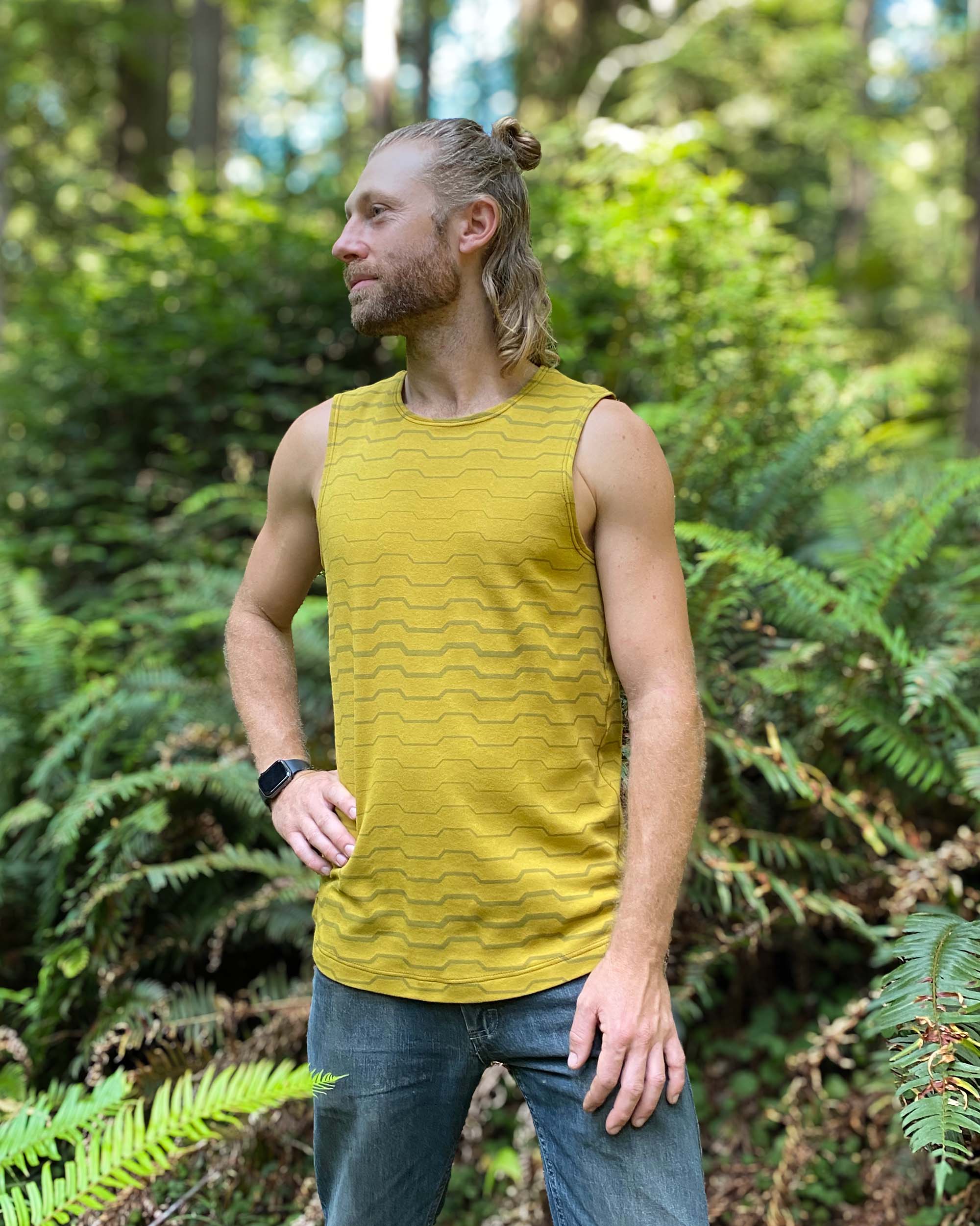 Organic cotton mens tank top, yellow fabric with geometric print, right side view on model.