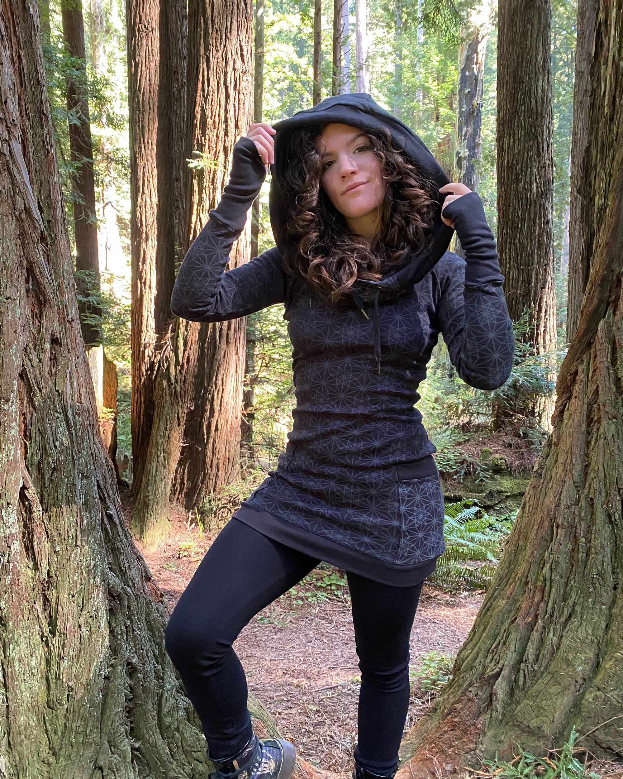 Organic cotton long sleeve tunic dress, black with geometric print, front view on female model.