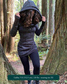 Organic cotton hooded long sleeve dress, black with geometric print, front view on female model.