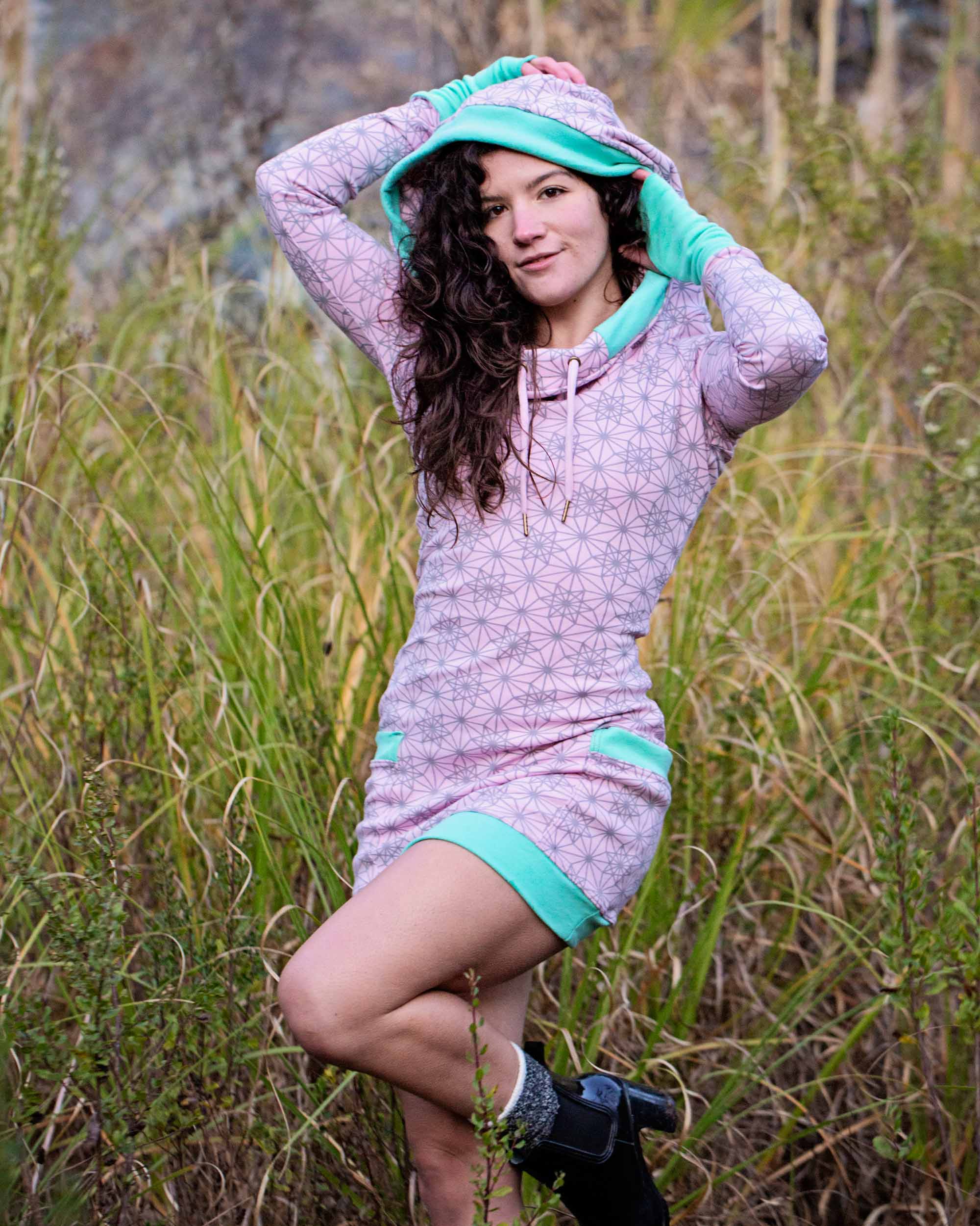 Organic cotton fitted tunic dress, pink fabric with geometric print, front view worn by female model.