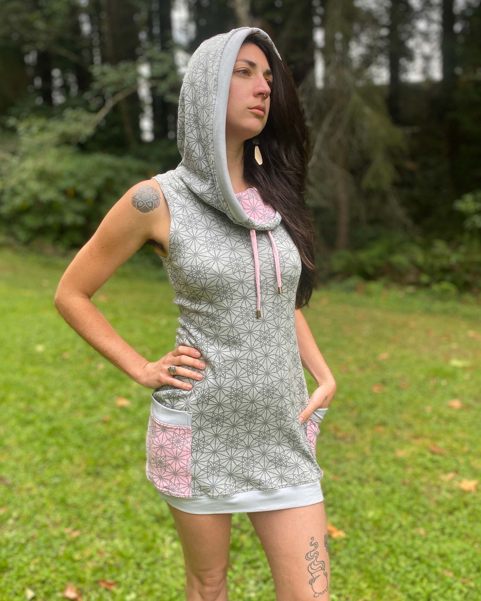 Organic cotton sleeveless tunic dress, grey fabric with geo print, front right side view on female model.