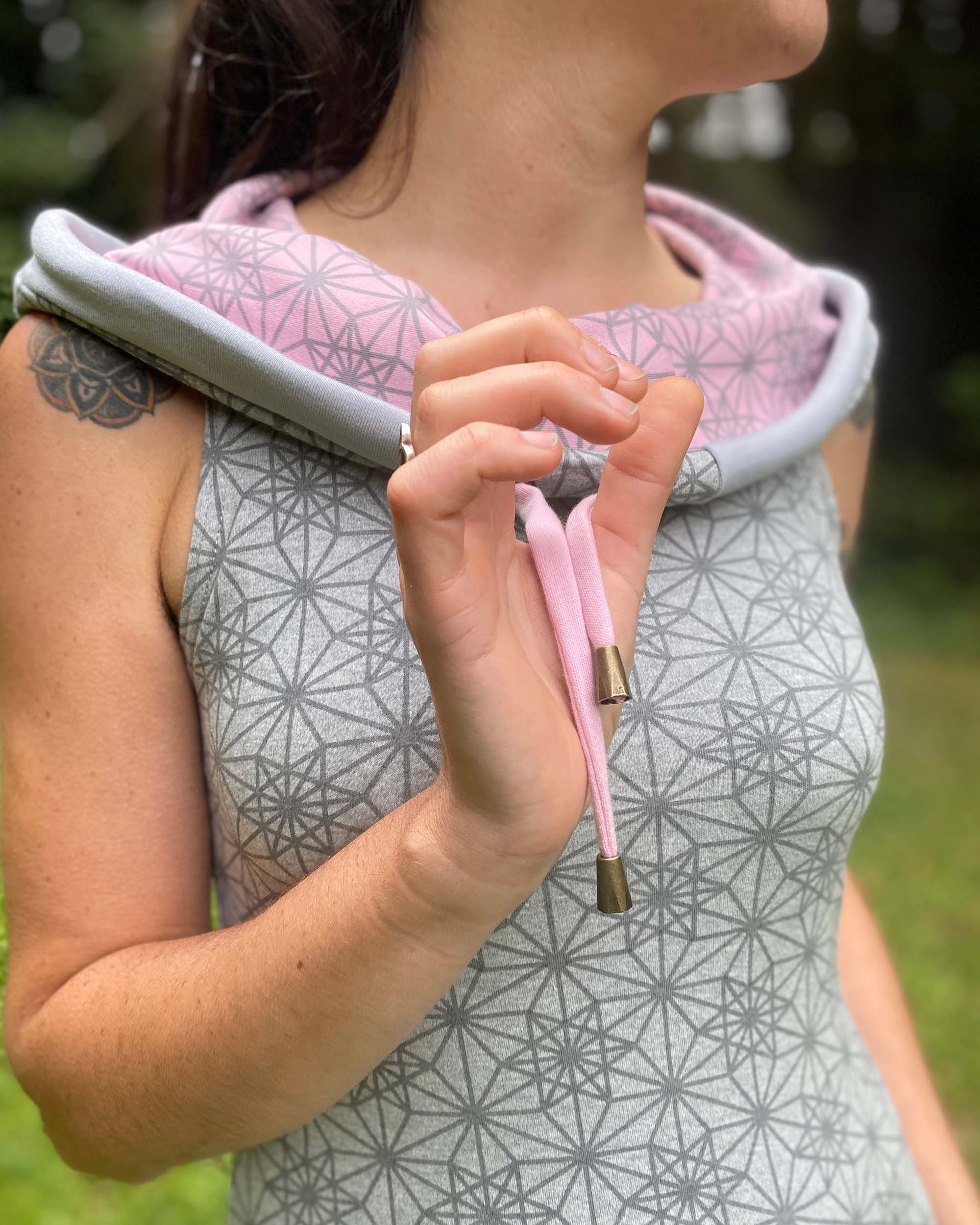 Organic cotton sleeveless tunic dress, grey fabric with pink accents, detail view of drawcord.