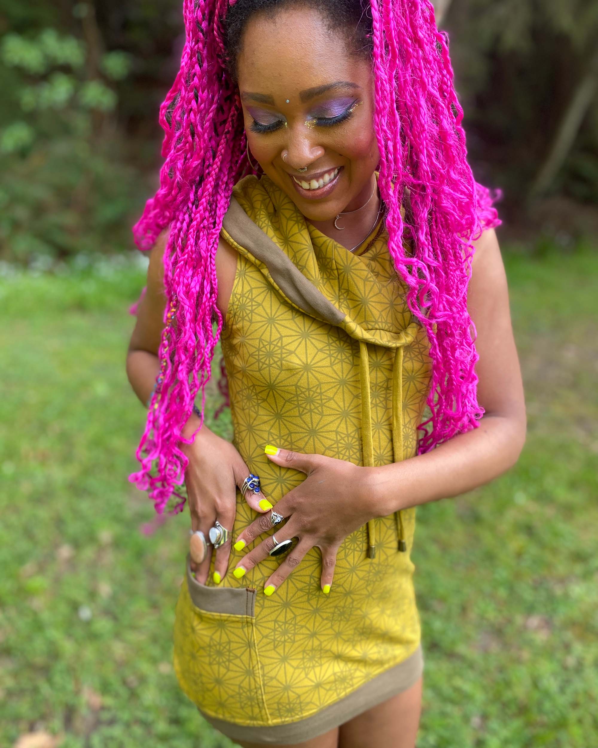 Organic cotton sleeveless tunic dress, yellow fabric with geometric print, front right side view on female model.