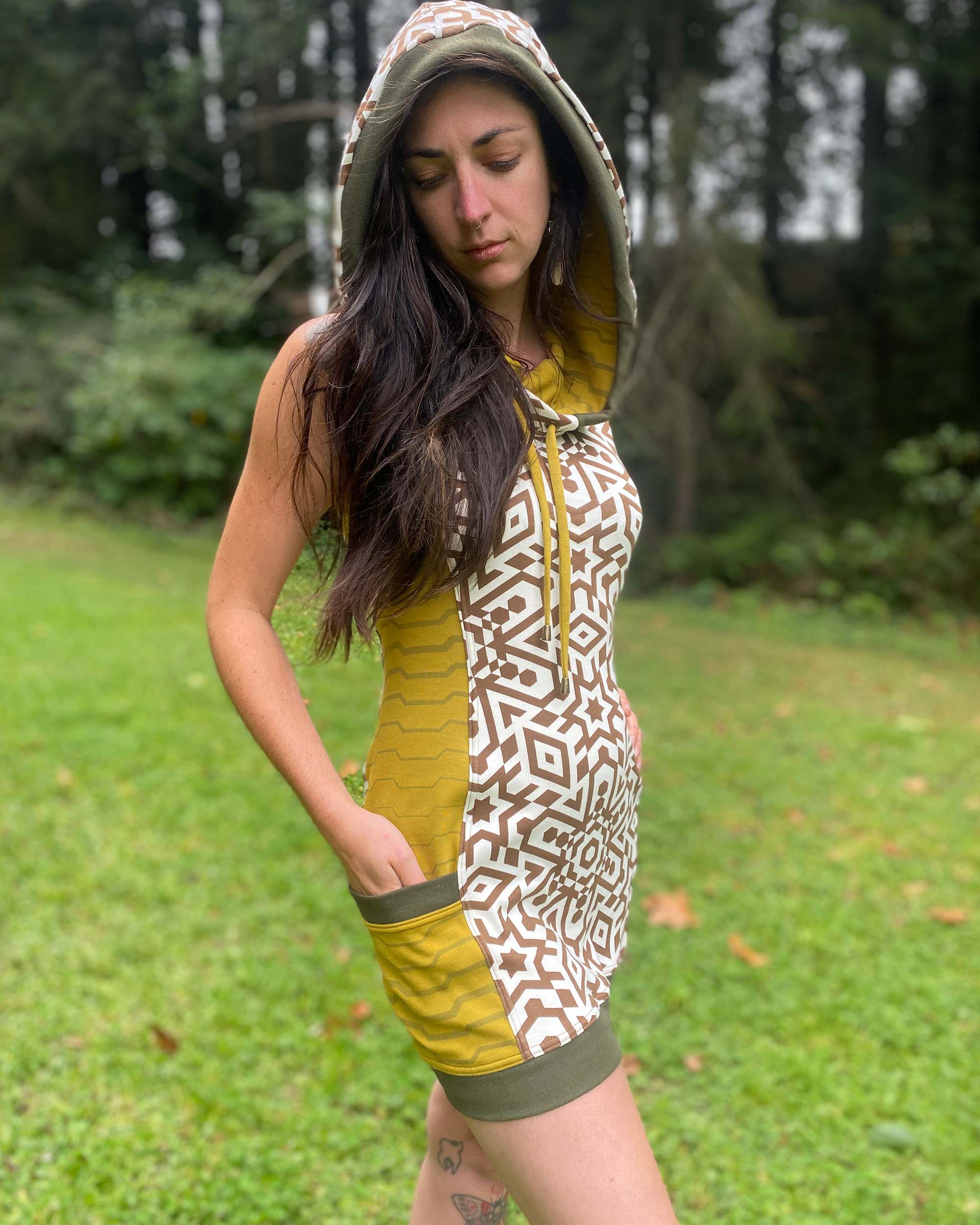 Organic cotton sleeveless hooded dress, undyed with geometric print, right side view of female model.