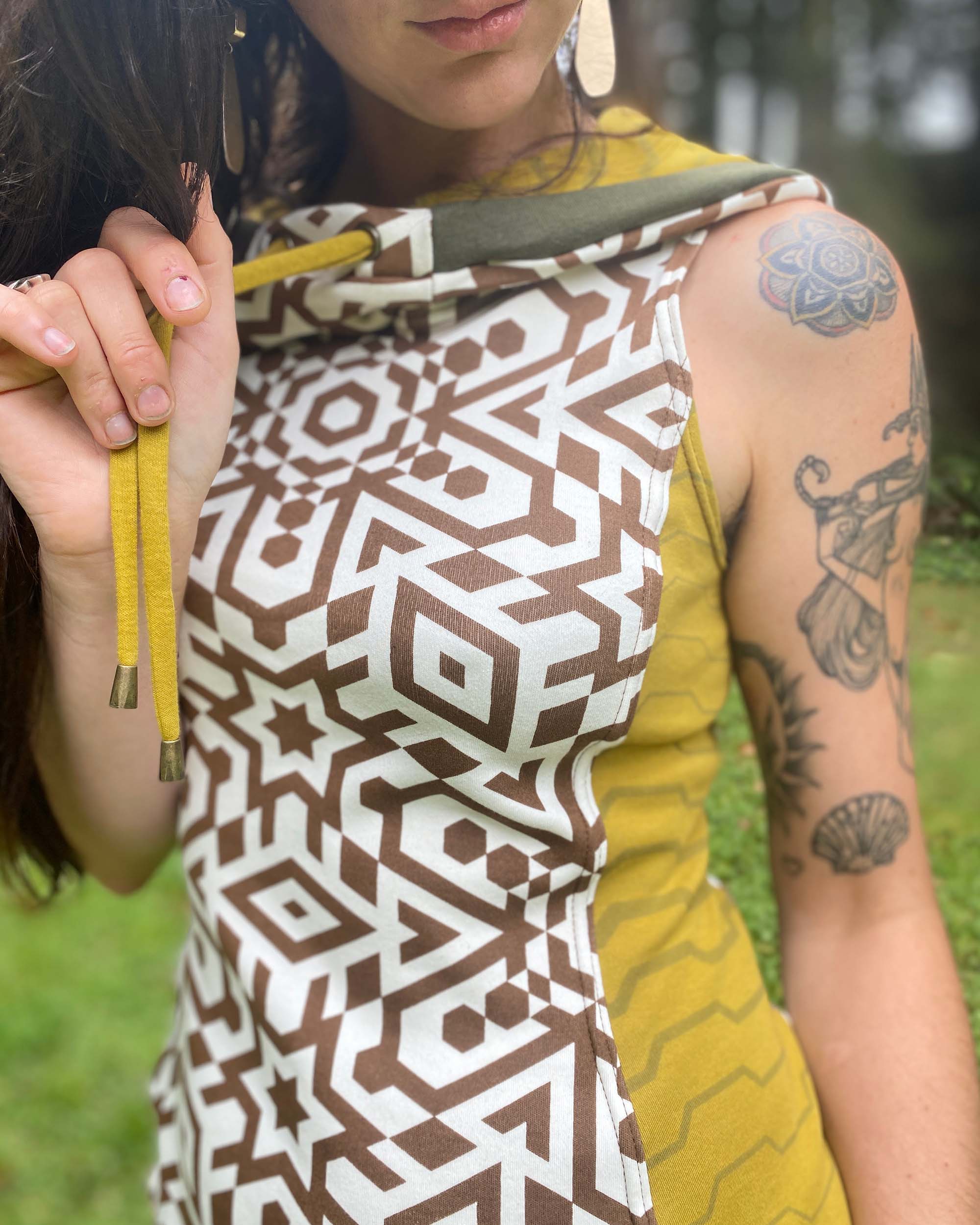 Organic cotton sleeveless hooded dress, undyed with geometric print, detail view of fabric.