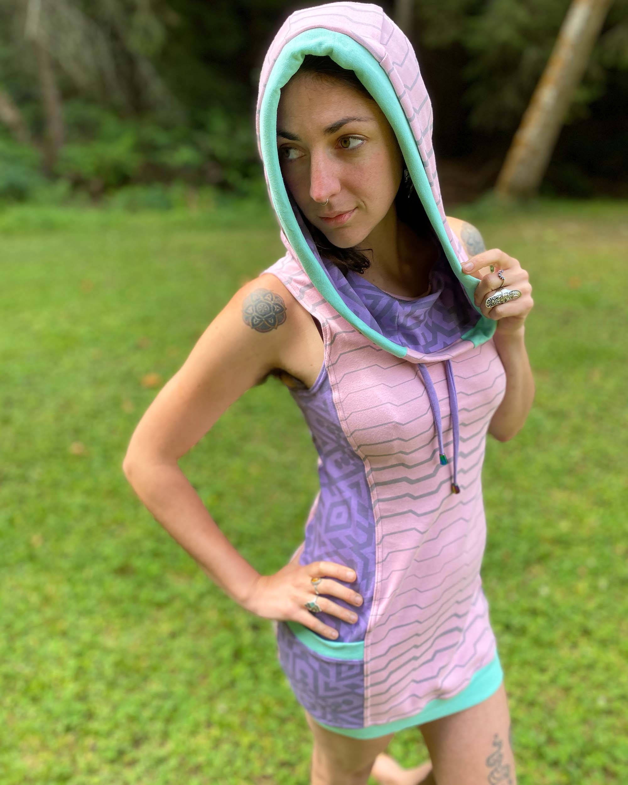 Organic cotton sleeveless tunic dress, pink and lavender colored fabric, front view on female model.