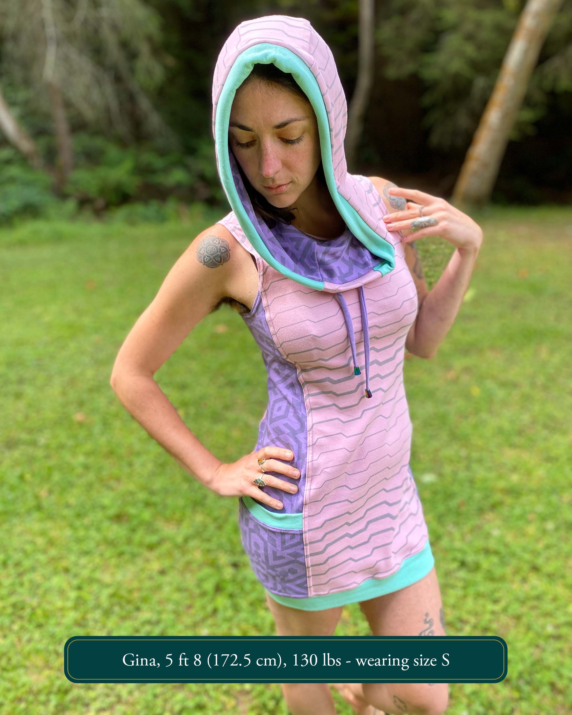 Organic cotton sleeveless hooded dress, pink with lavender colored accents, front view on female model.