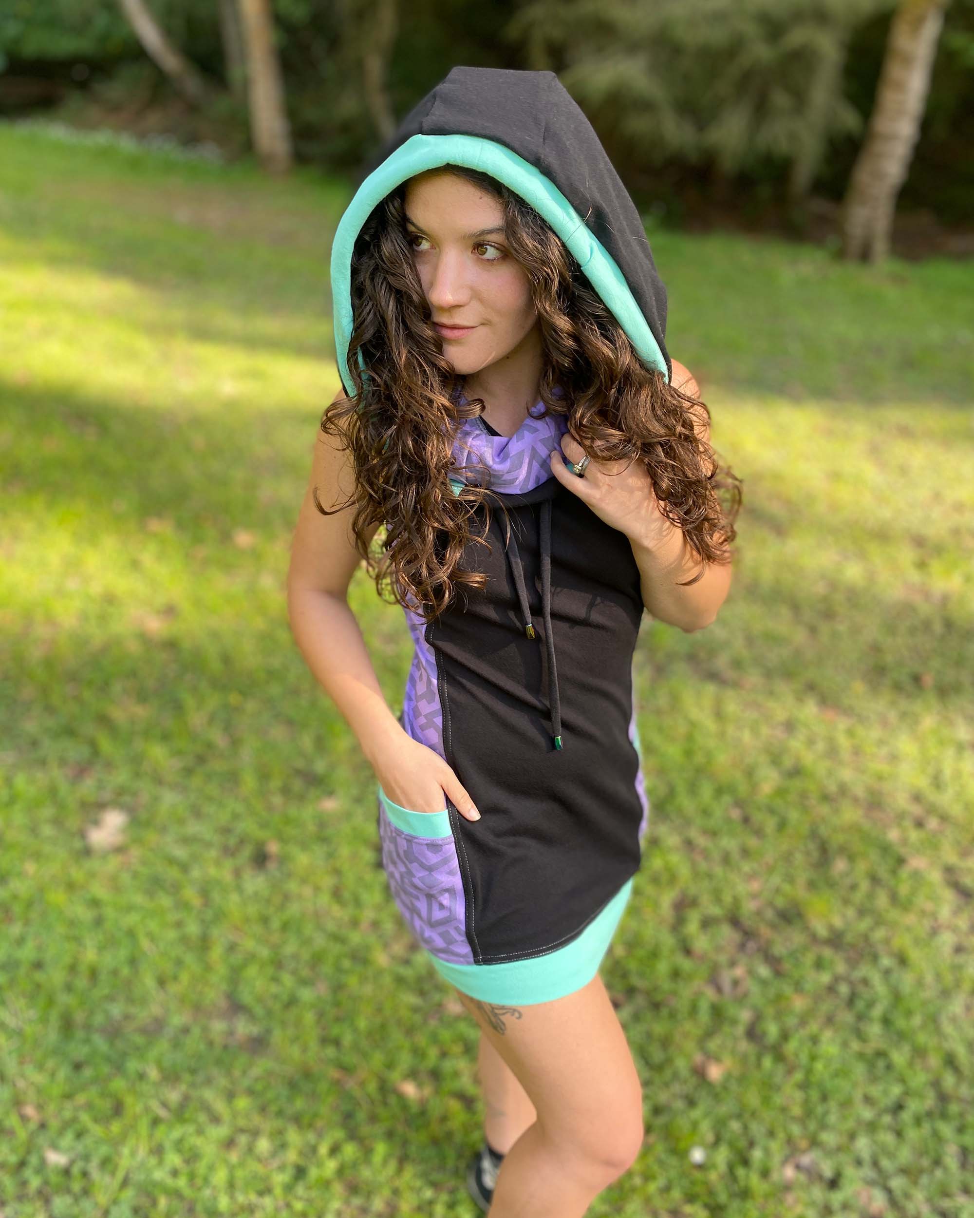 Organic cotton sleeveless hooded dress, black with lavender fabric accents, detail view of pocket.