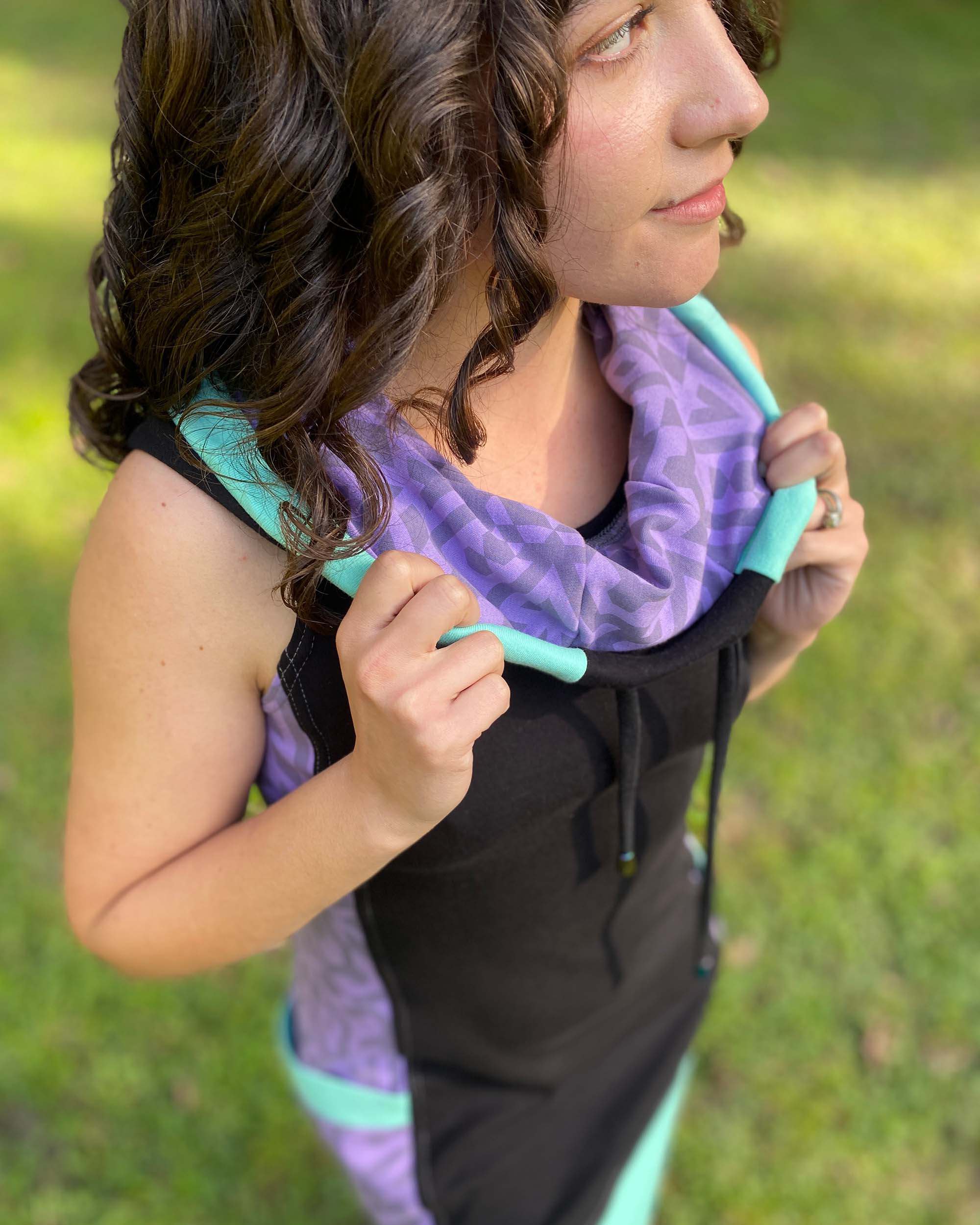 Organic cotton sleeveless hooded dress, black with lavender fabric accents, detail view of hood.