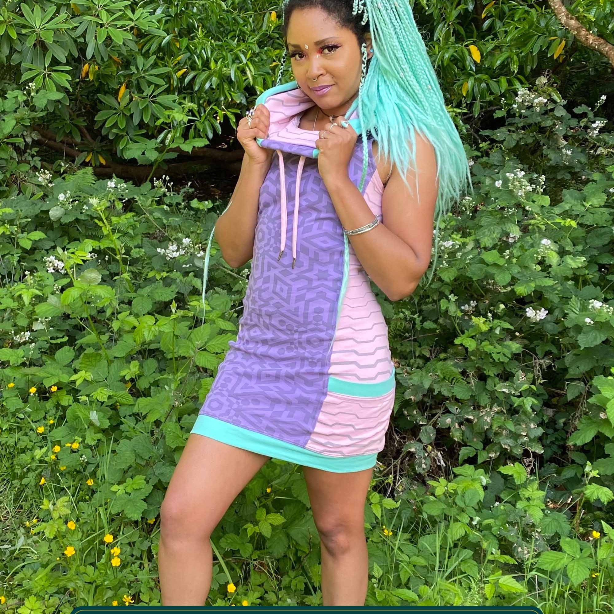 Organic cotton sleeveless hooded dress, lavender fabric with pink accents, front view worn by female model.