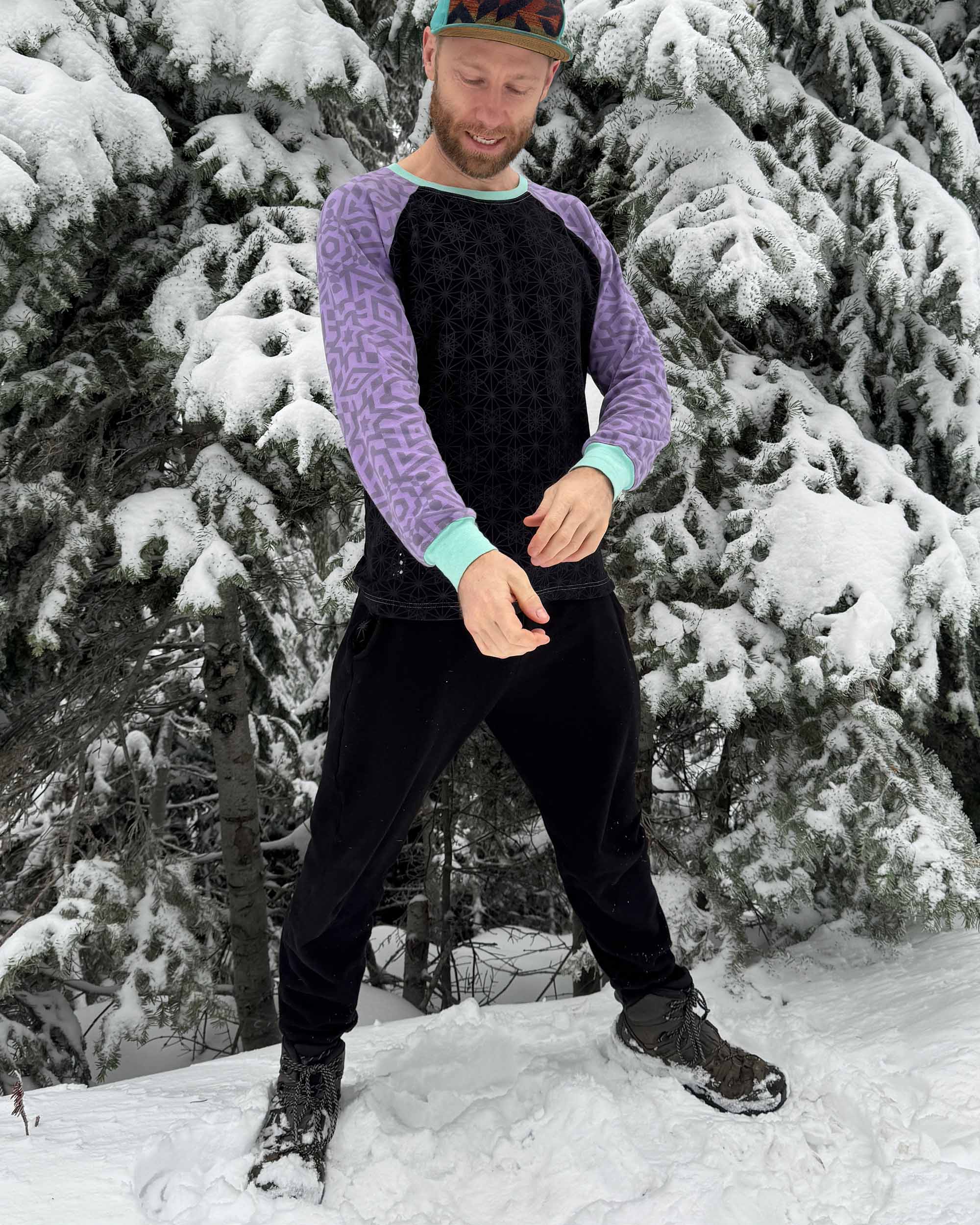 Organic cotton fleece joggers, solid black fabric, front view on male model in the cold.