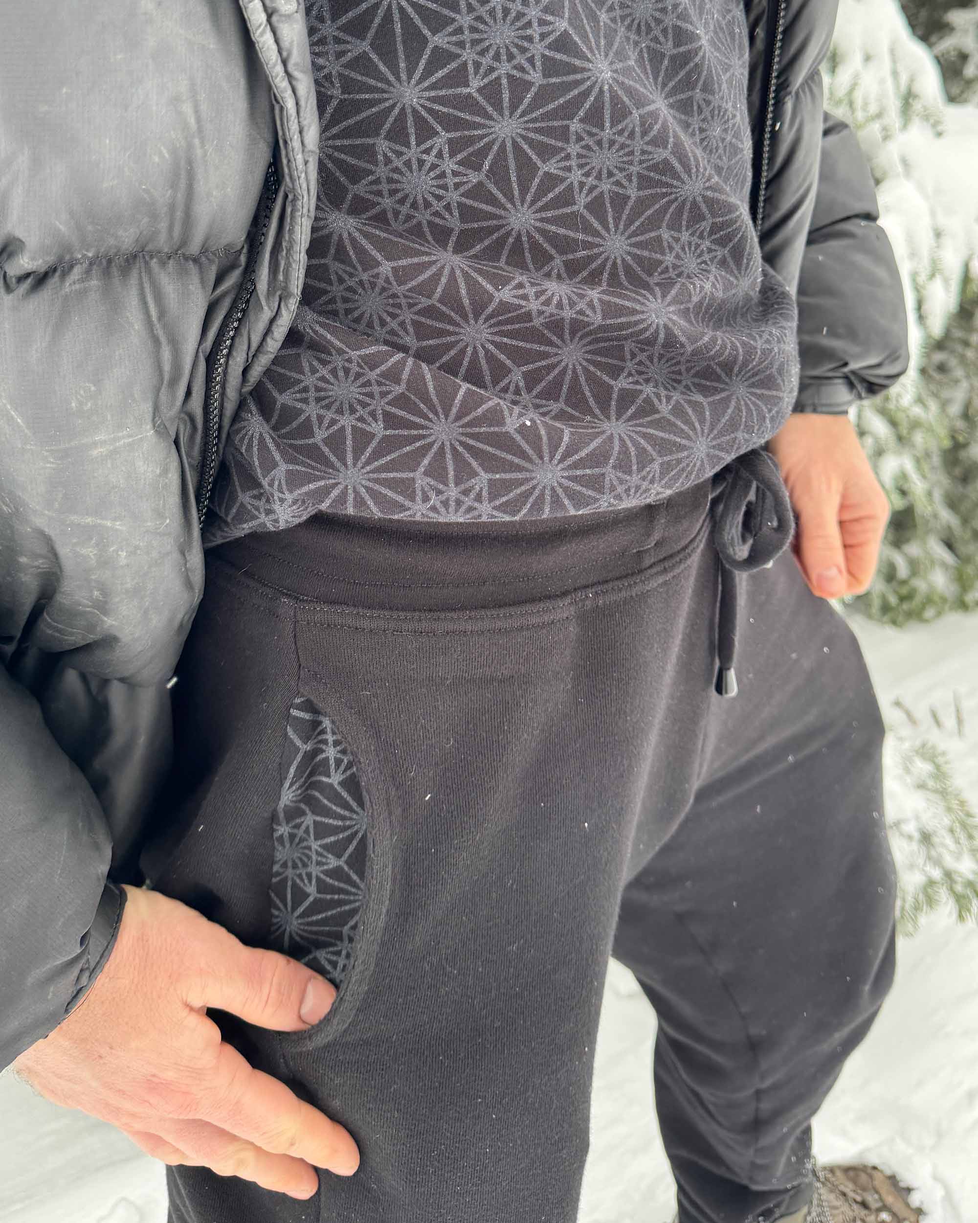Organic cotton fleece joggers, solid black fabric, detail view of the pocket lining.