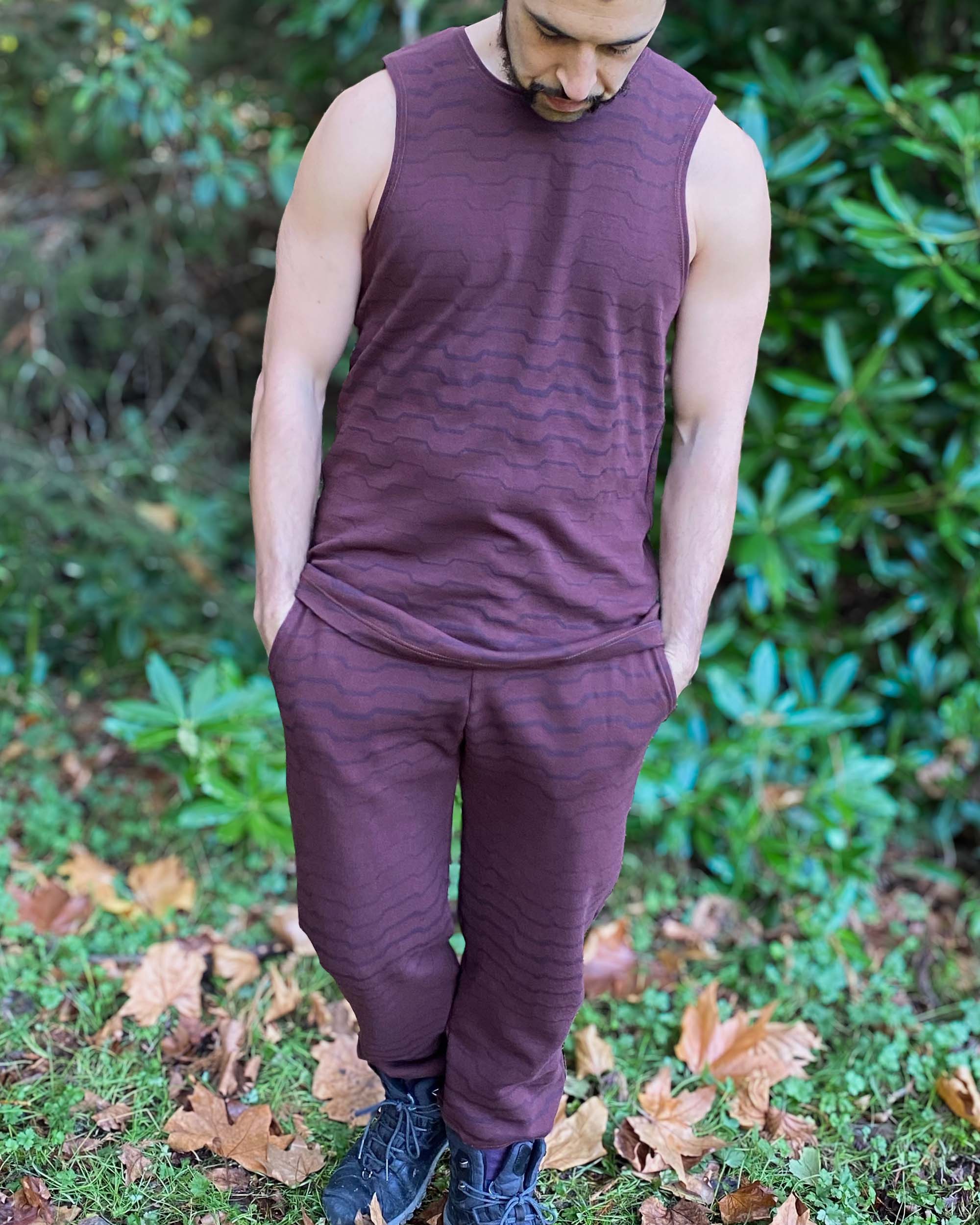 Male model wearing reddish brown fabric with geometric print matching tank top and fleece joggers.