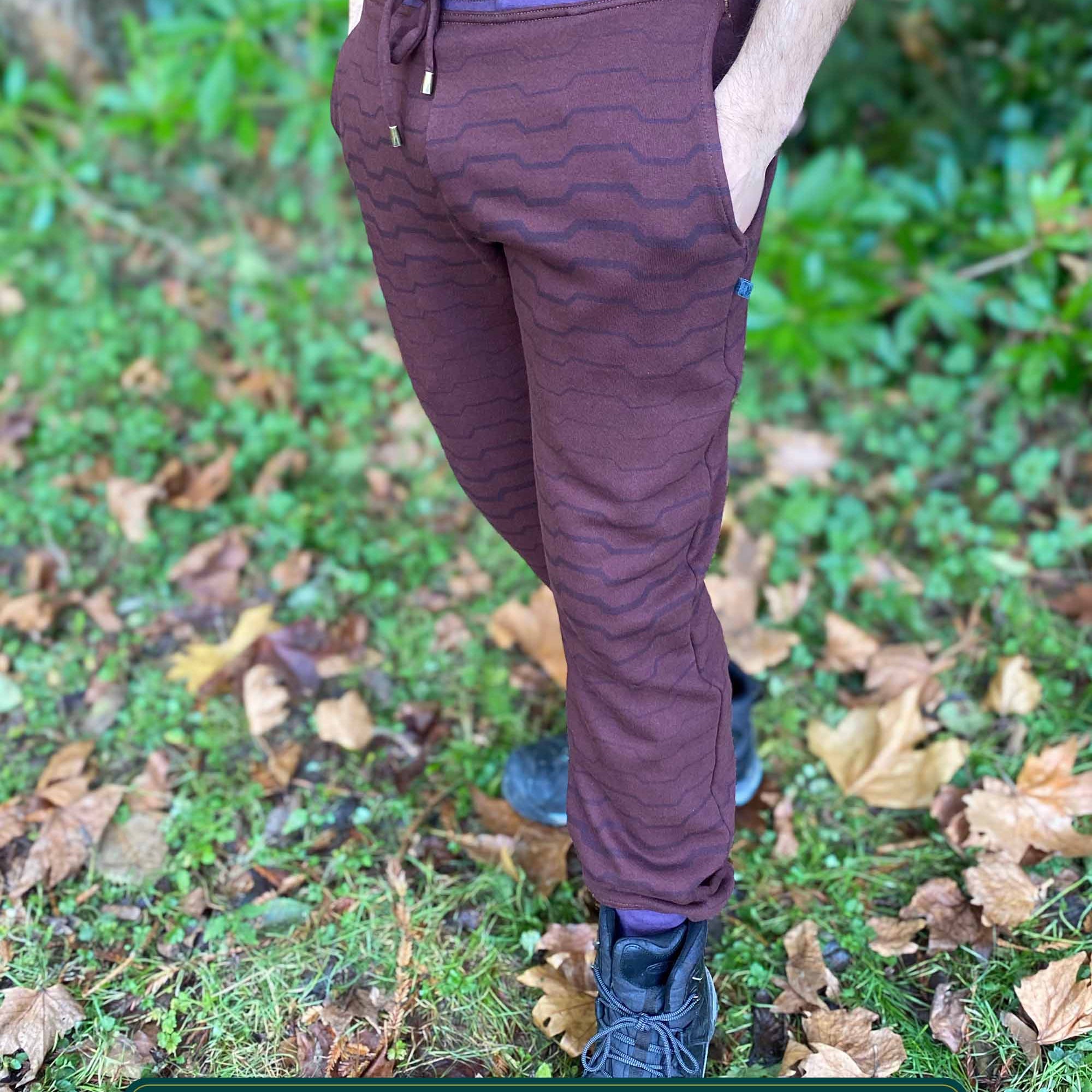 Organic cotton fleece joggers, reddish brown fabric with geometric all over print, front view on male model.