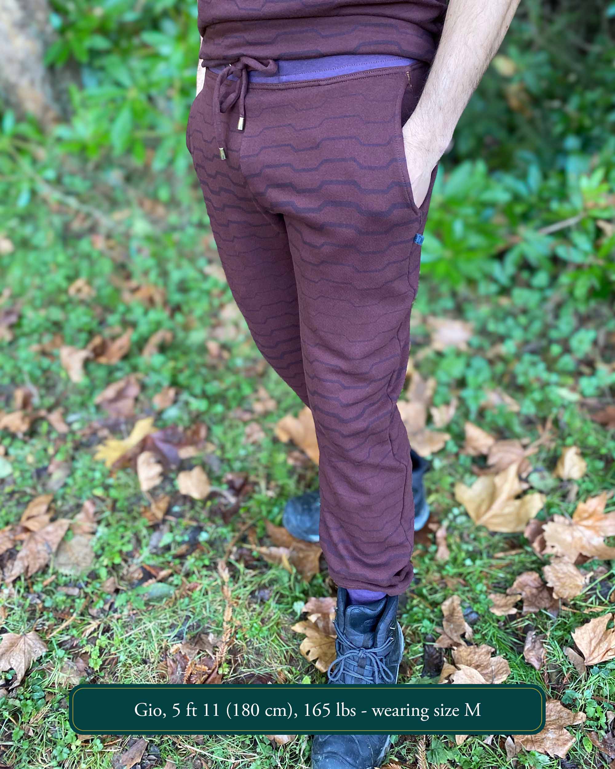 Organic cotton fleece joggers, reddish brown fabric with geometric all over print, front view on male model.