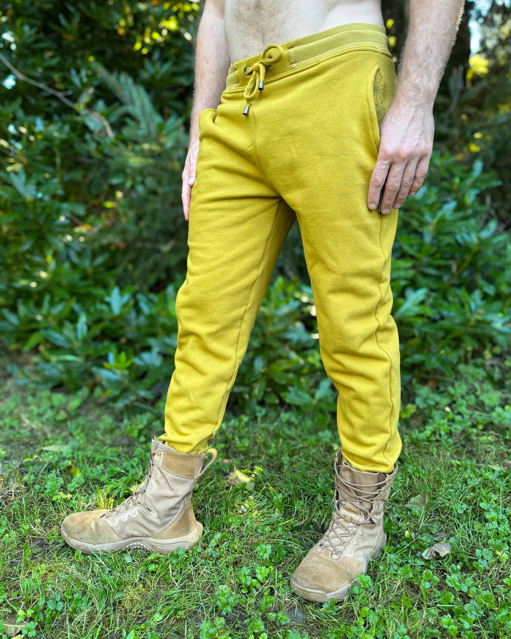 Organic cotton fleece joggers, solid yellow fabric, left side view on male model.