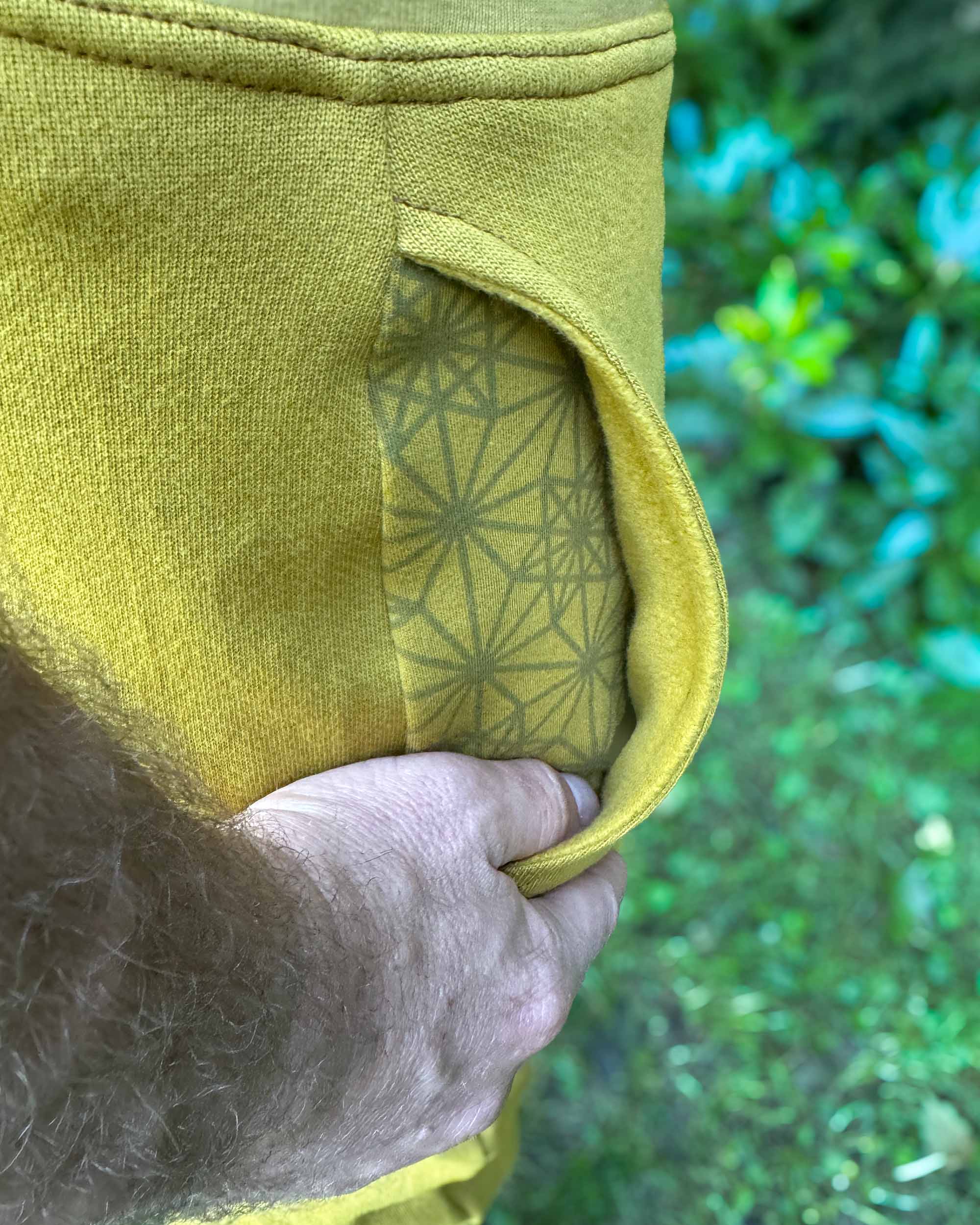 Organic cotton fleece joggers, solid yellow fabric, detail of inside fleece lined pocket.