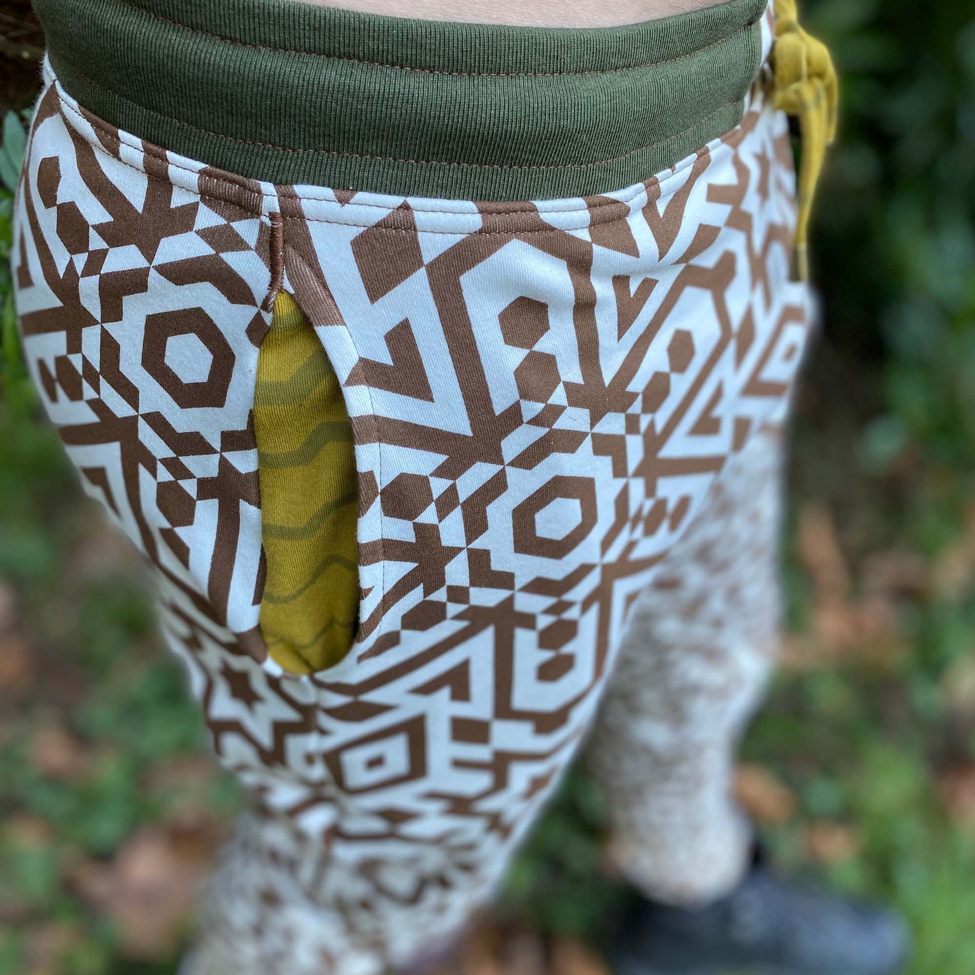 Organic cotton unisex joggers, undyed fabric with brown geometric print, detail view of the pocket lining.