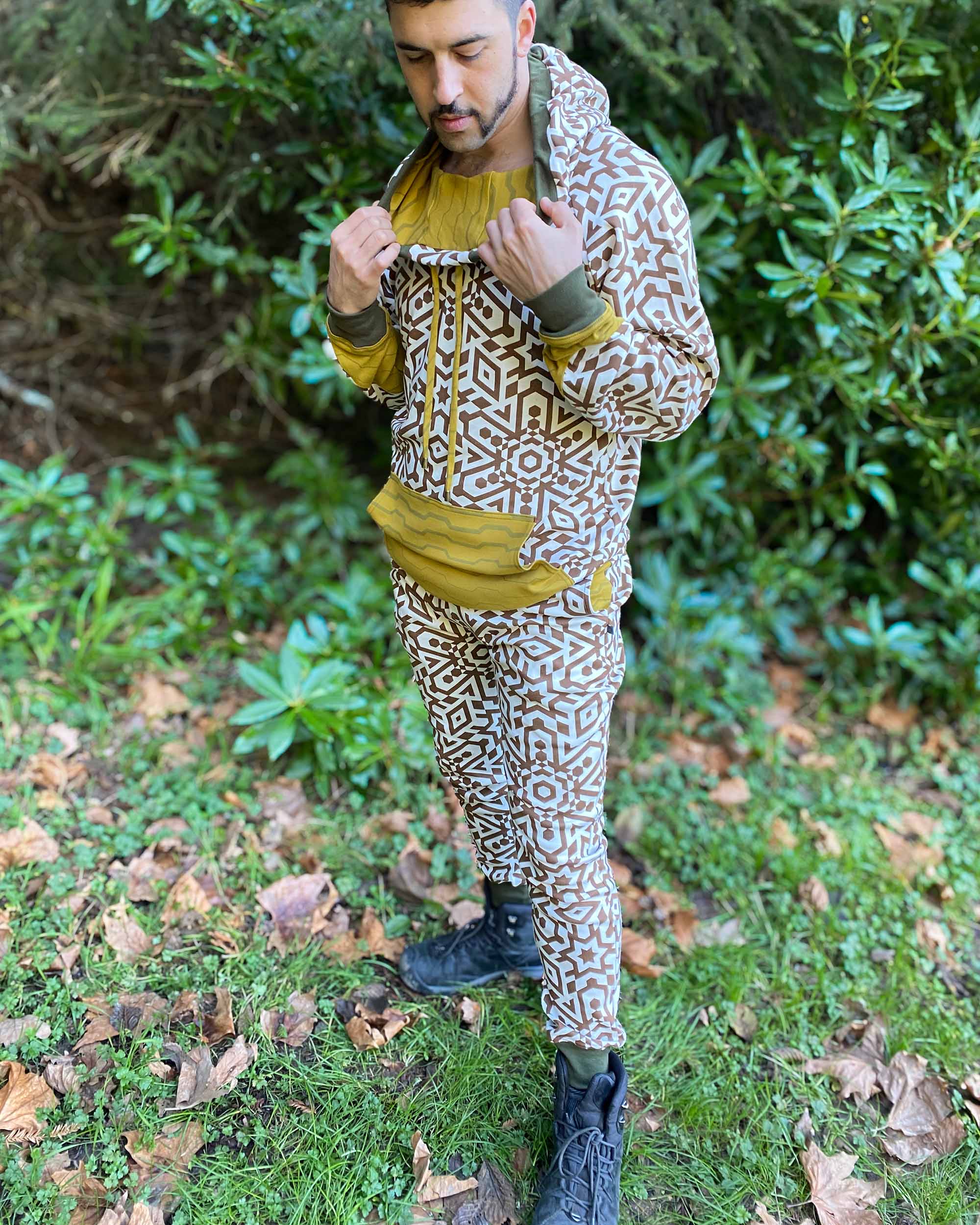 Male model in organic cotton unisex joggers and matching undyed hoodie with brown geometric print.