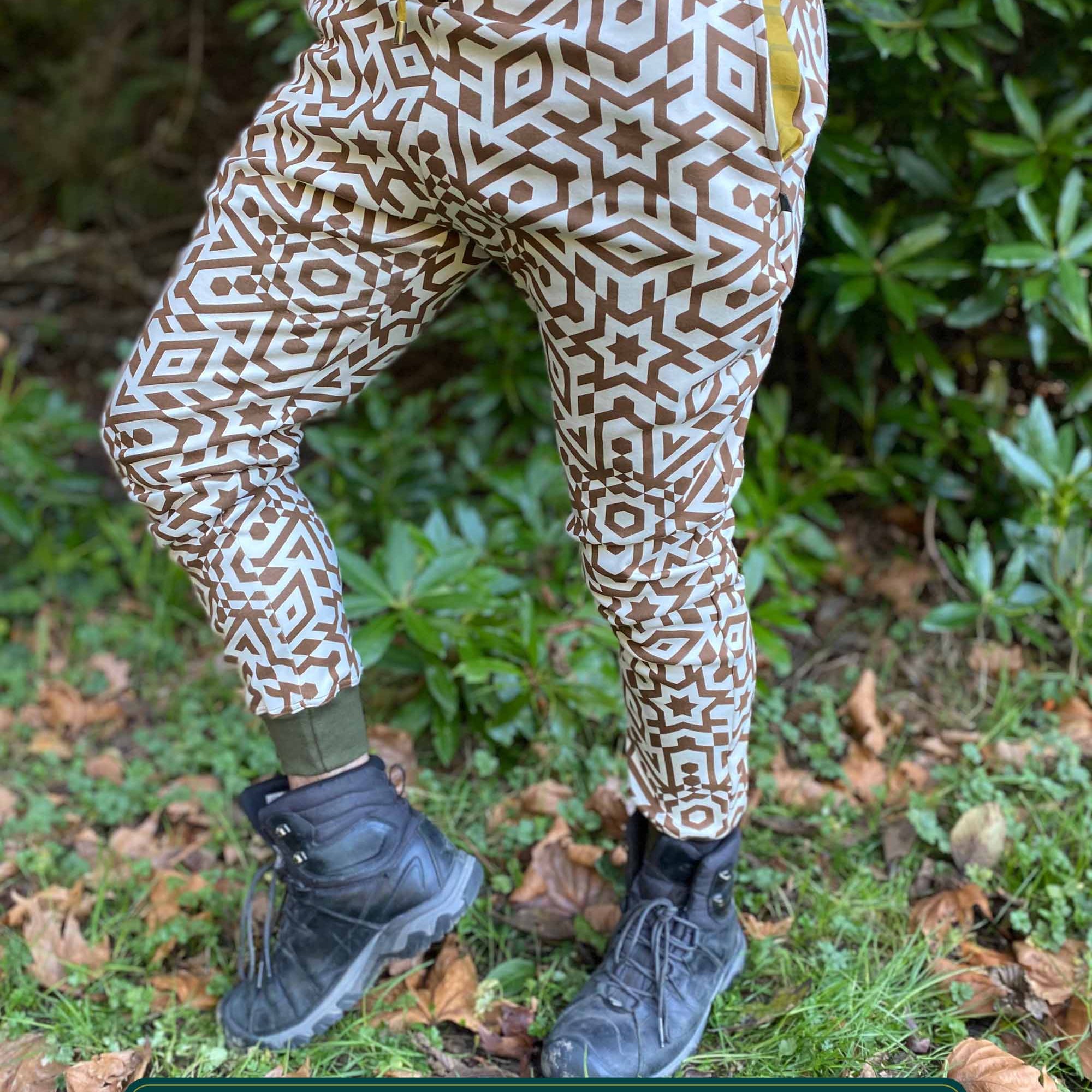 Organic cotton unisex joggers, undyed fabric with brown geometric print, left side view on male model.