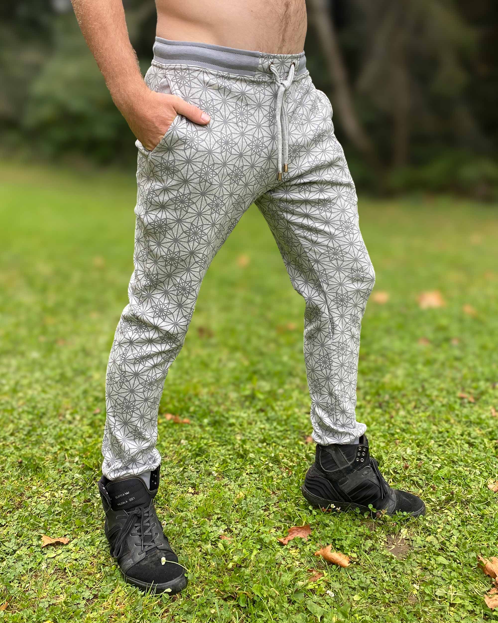 Organic cotton unisex joggers, grey fabric with geometric print, front right side view on male model.