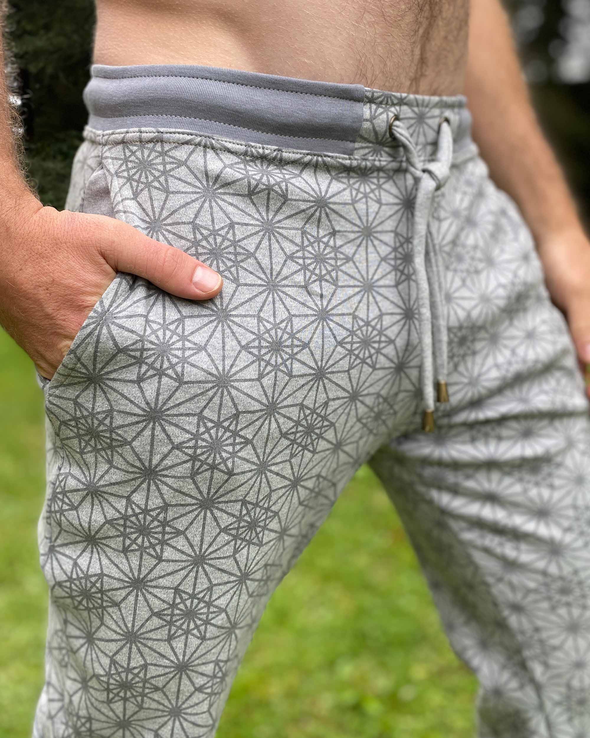 Organic cotton unisex joggers, grey fabric with geometric print, detail side view of waistband.
