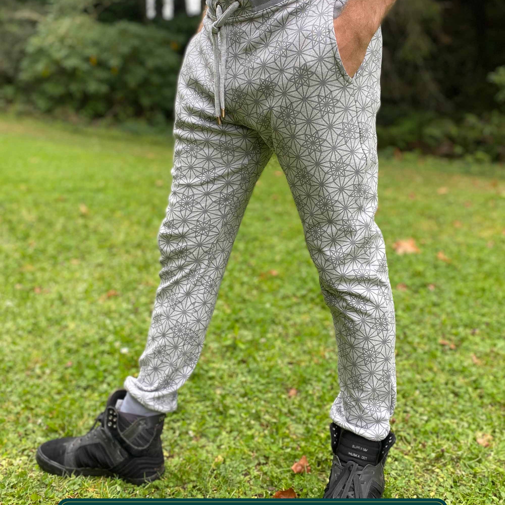 Organic cotton unisex joggers, grey fabric with geometric print, left side view on male model.