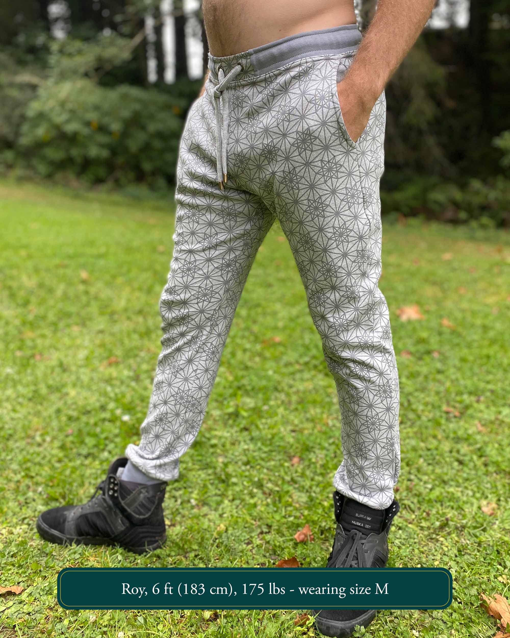Organic cotton unisex joggers, grey fabric with geometric print, left side view on male model.
