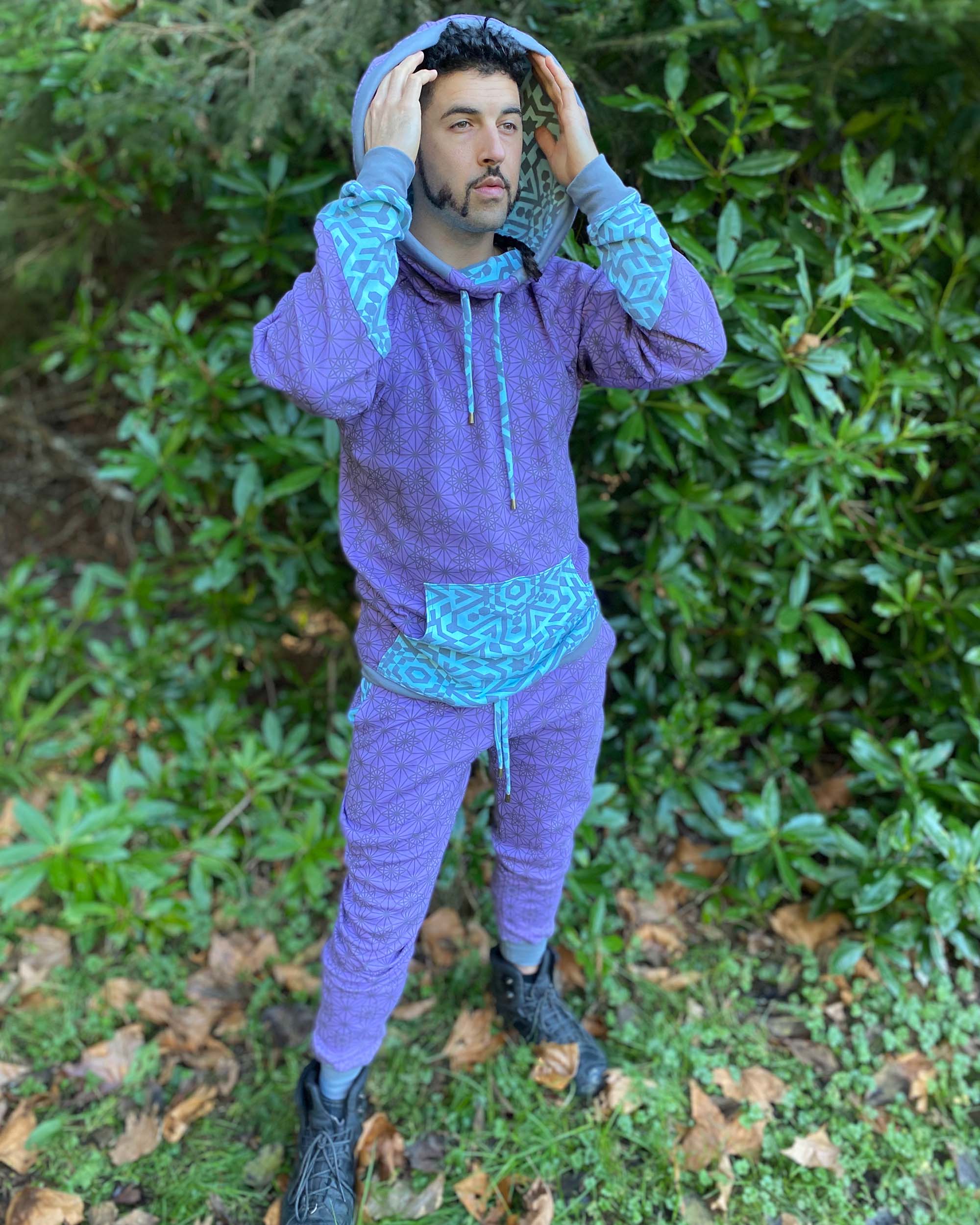 Organic cotton unisex joggers, lavender fabric with geometric print and blue accents, full body view on male model.