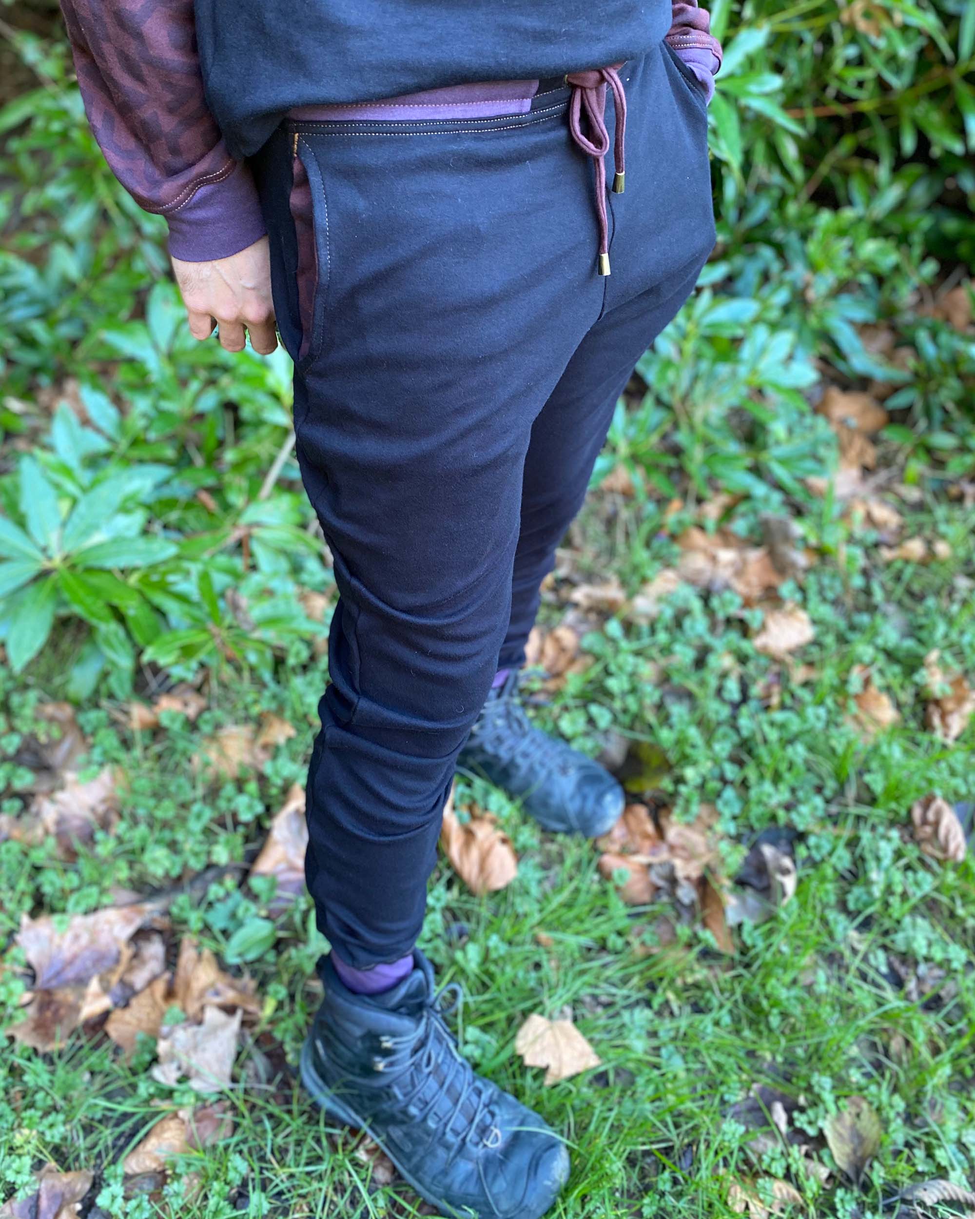 Organic cotton unisex joggers, black fabric with brown accents, front right view on male model.