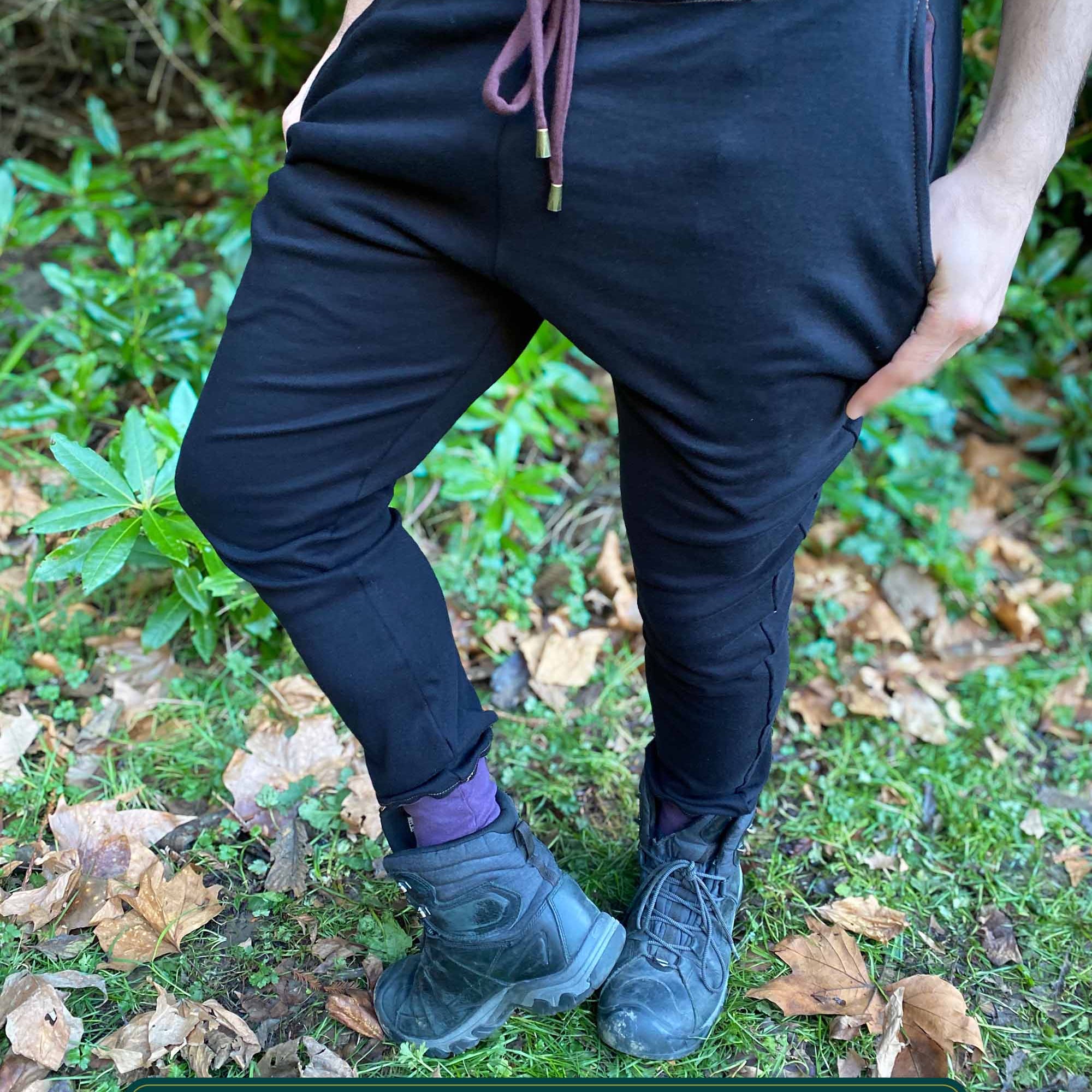 Organic cotton unisex joggers, black fabric with brown accents, front view on male model.
