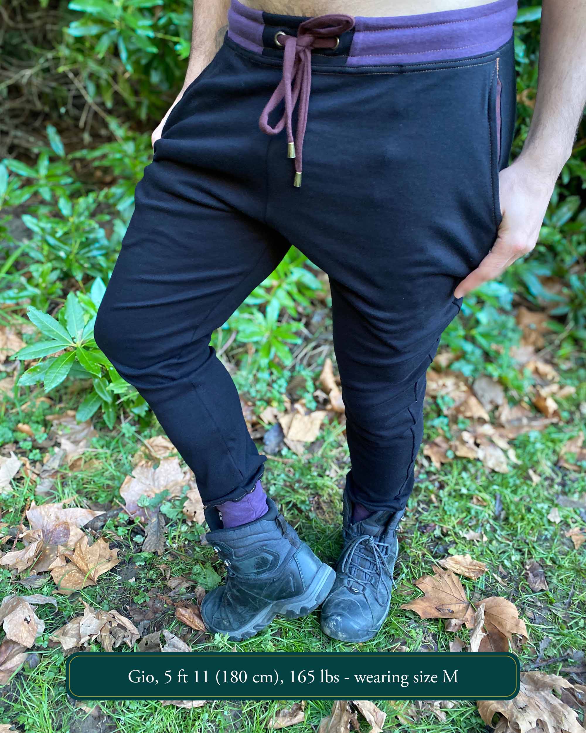 Organic cotton unisex joggers, black fabric with brown accents, front view on male model.